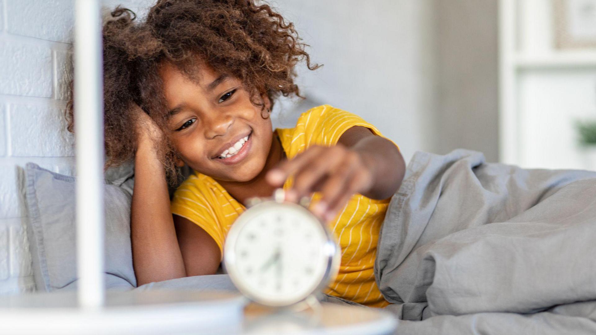 Child with alarm clock.