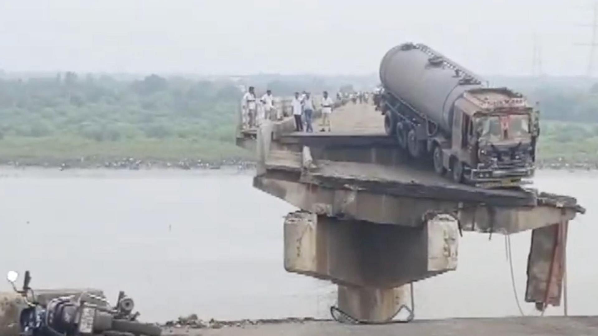 A truck stuck at the precipice of a collapsed bridge in Gujarat