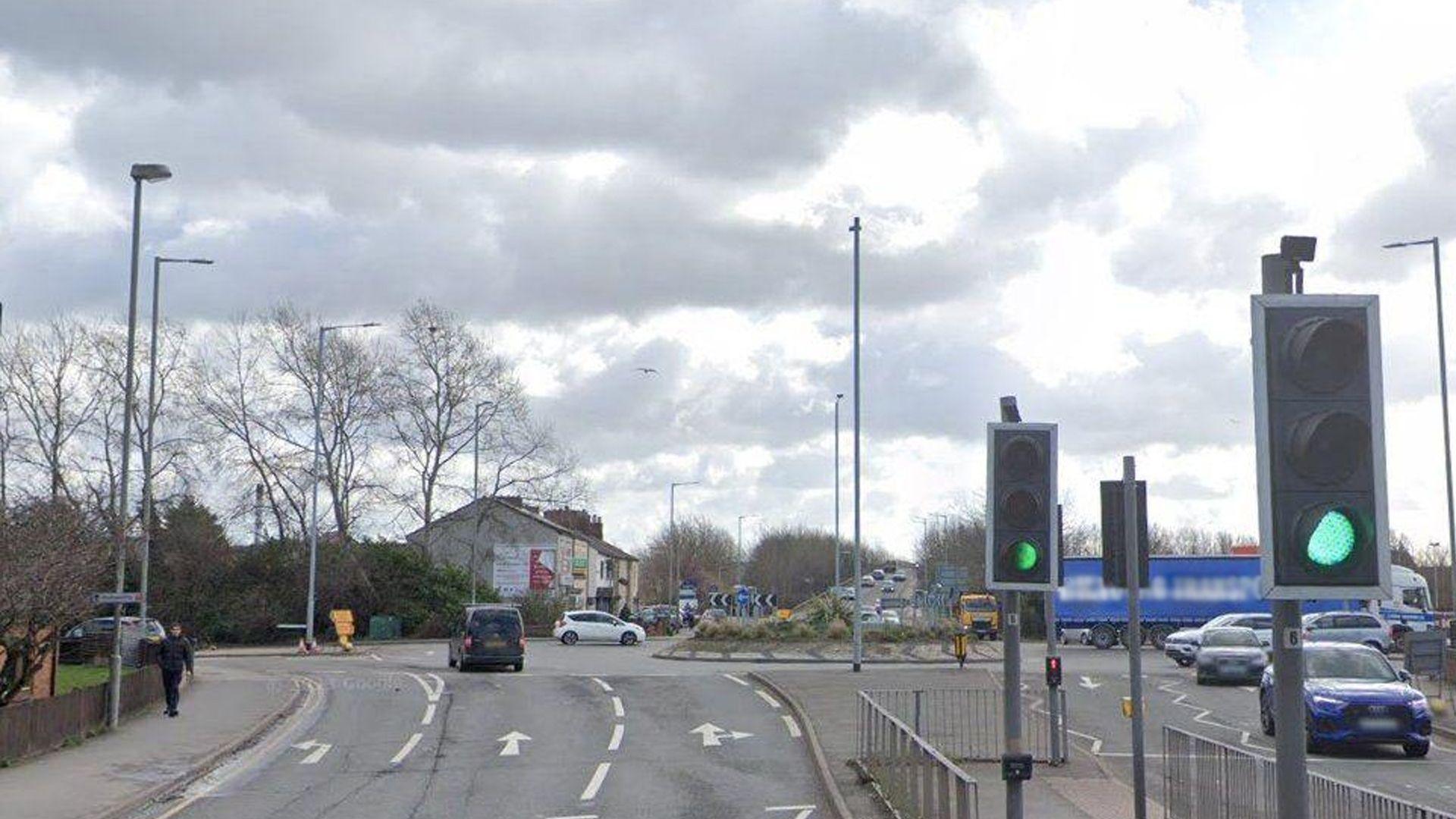 The junction where the boy died, a roundabout with three lanes of traffic on the approach. There is a pedestrian crossing in the foreground ahead of the roundabout.