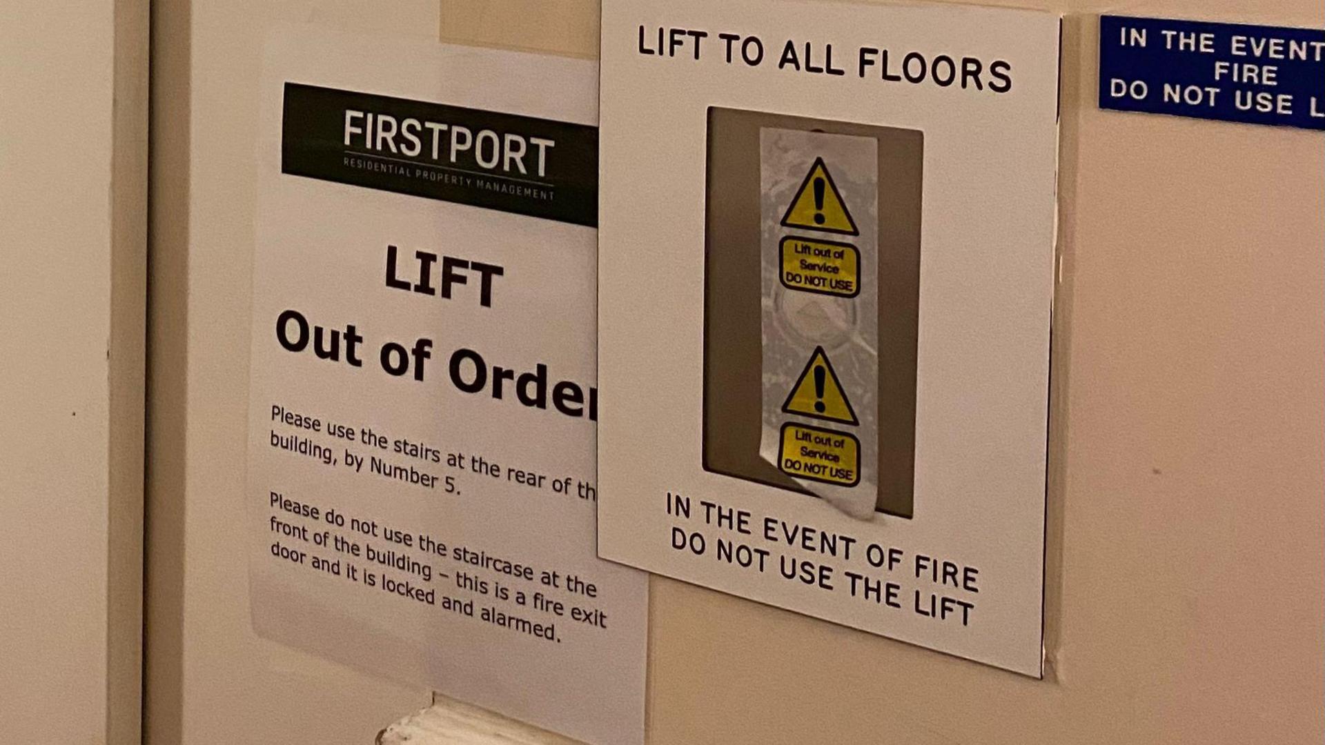 A lift out of order sign put up by the property management company First Port. It is next to a sign warning people to not use the lift in the event of a fire.