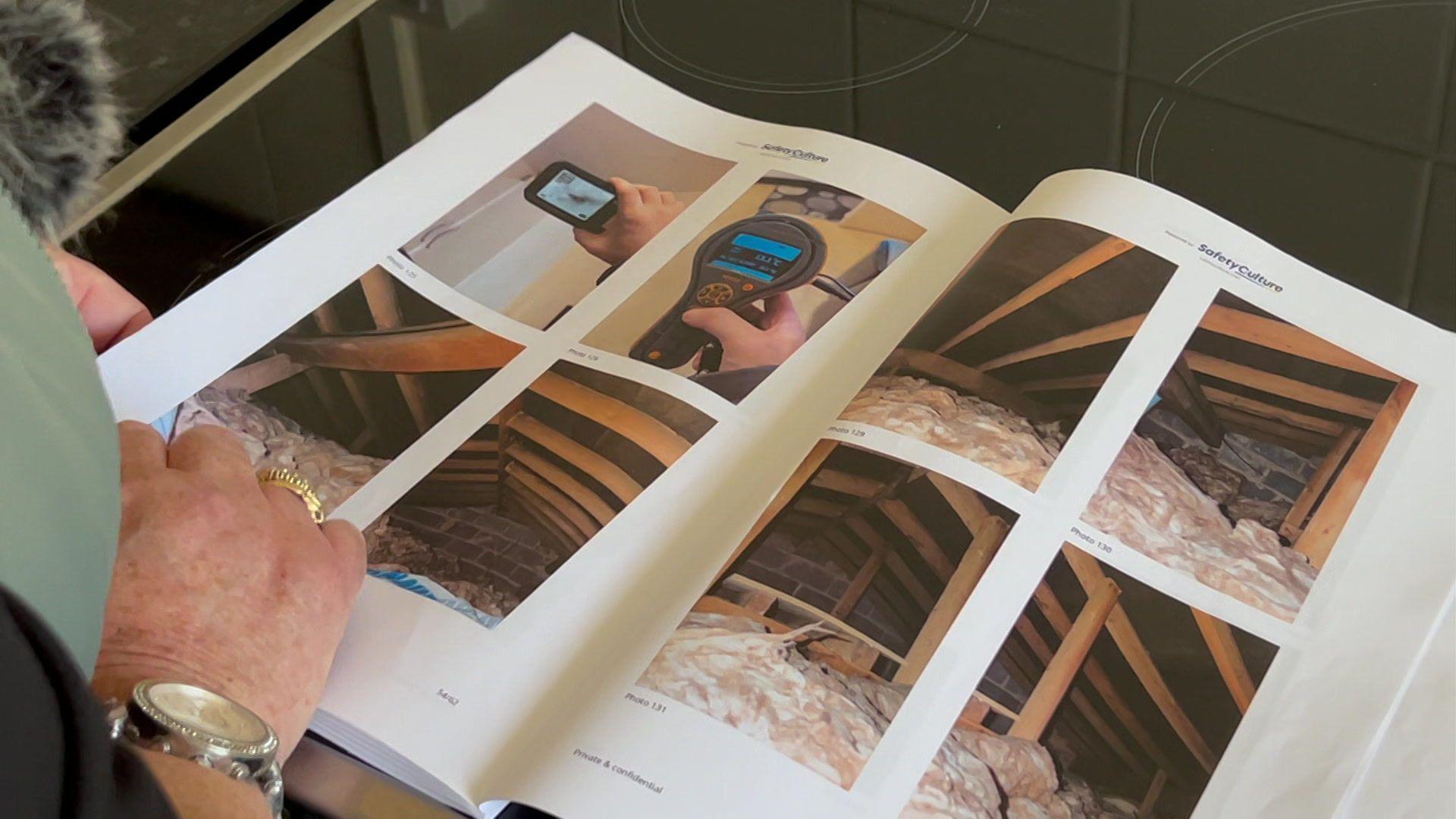 A woman's hand turning the pages of a book with various photographs in it.