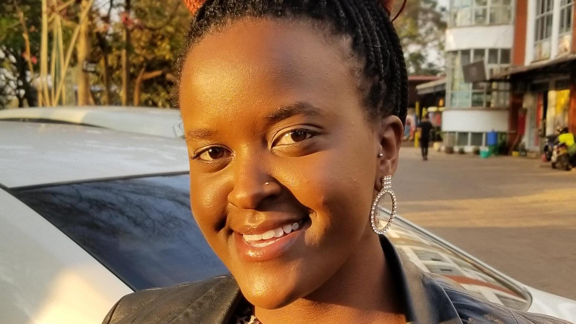 A close-up of Nelly Naisula Sironka smiling with  one hooped bejewelled earring visible