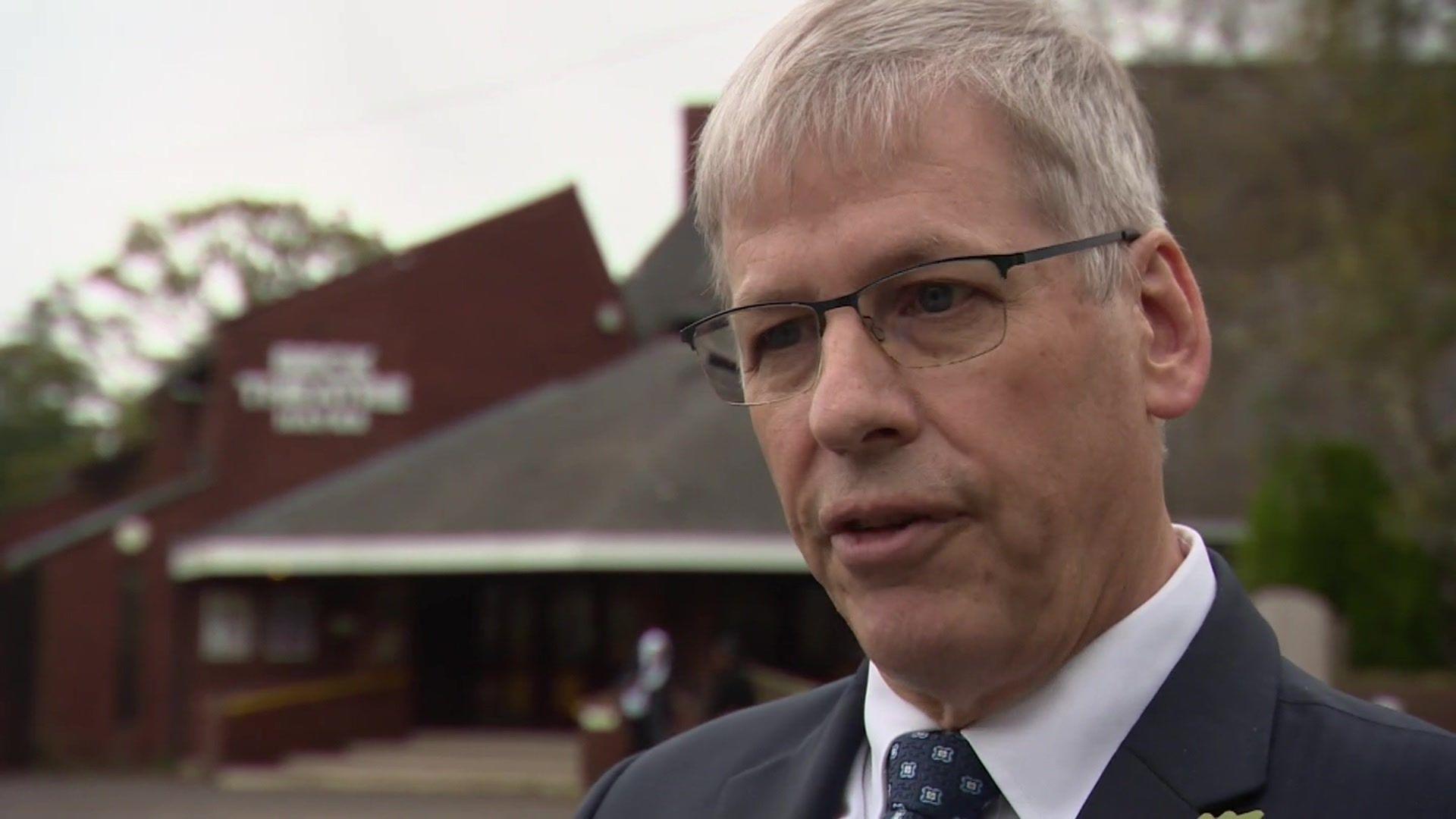 Council leader Ian Edwards wearing a suit and tie speaking to the BBC outside the theatre