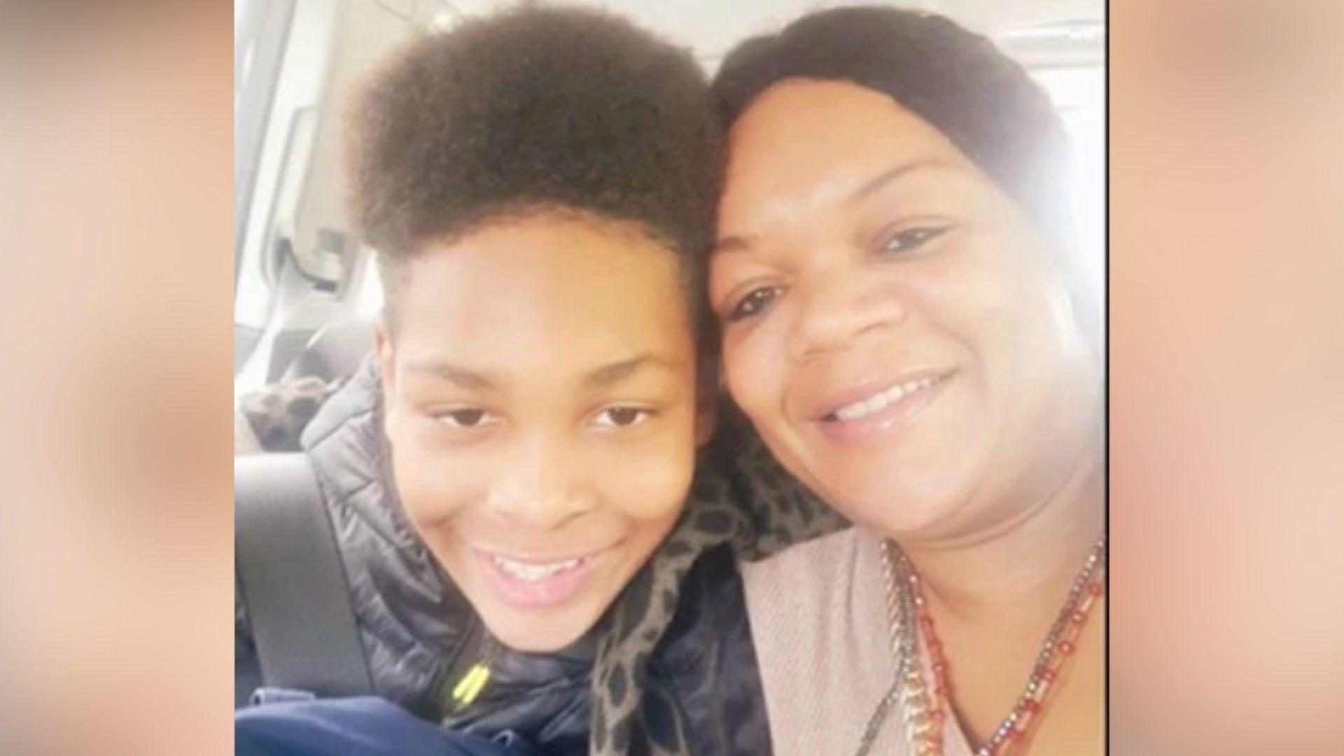 A selfie-style picture of Kelyan with his mother, both smiling at the camera. 