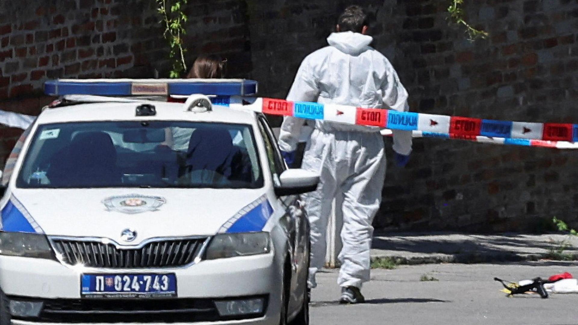 A forensics officer is seen near a crossbow that has been cordened off by police on the road outside the Israeli embassy in Belgrade.