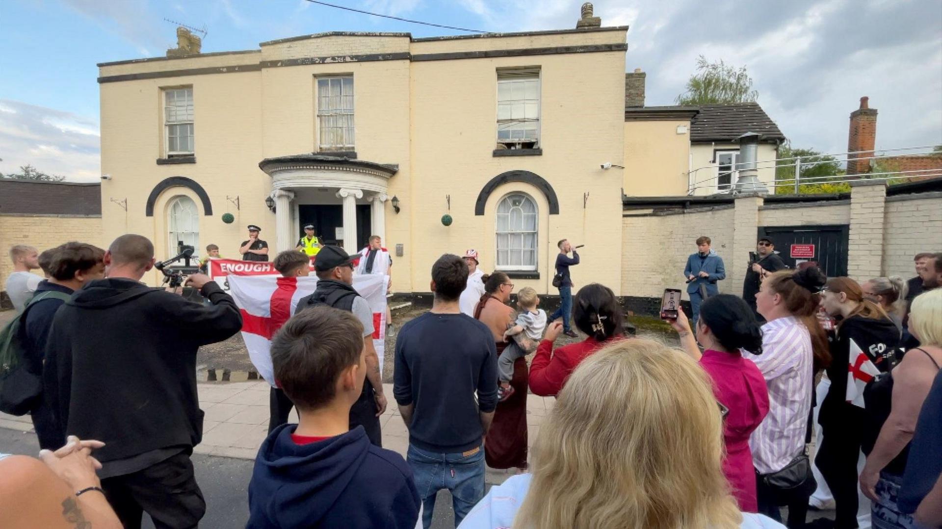 Around 20 protesters outside the Park Hotel. Some are waving St George's flags.