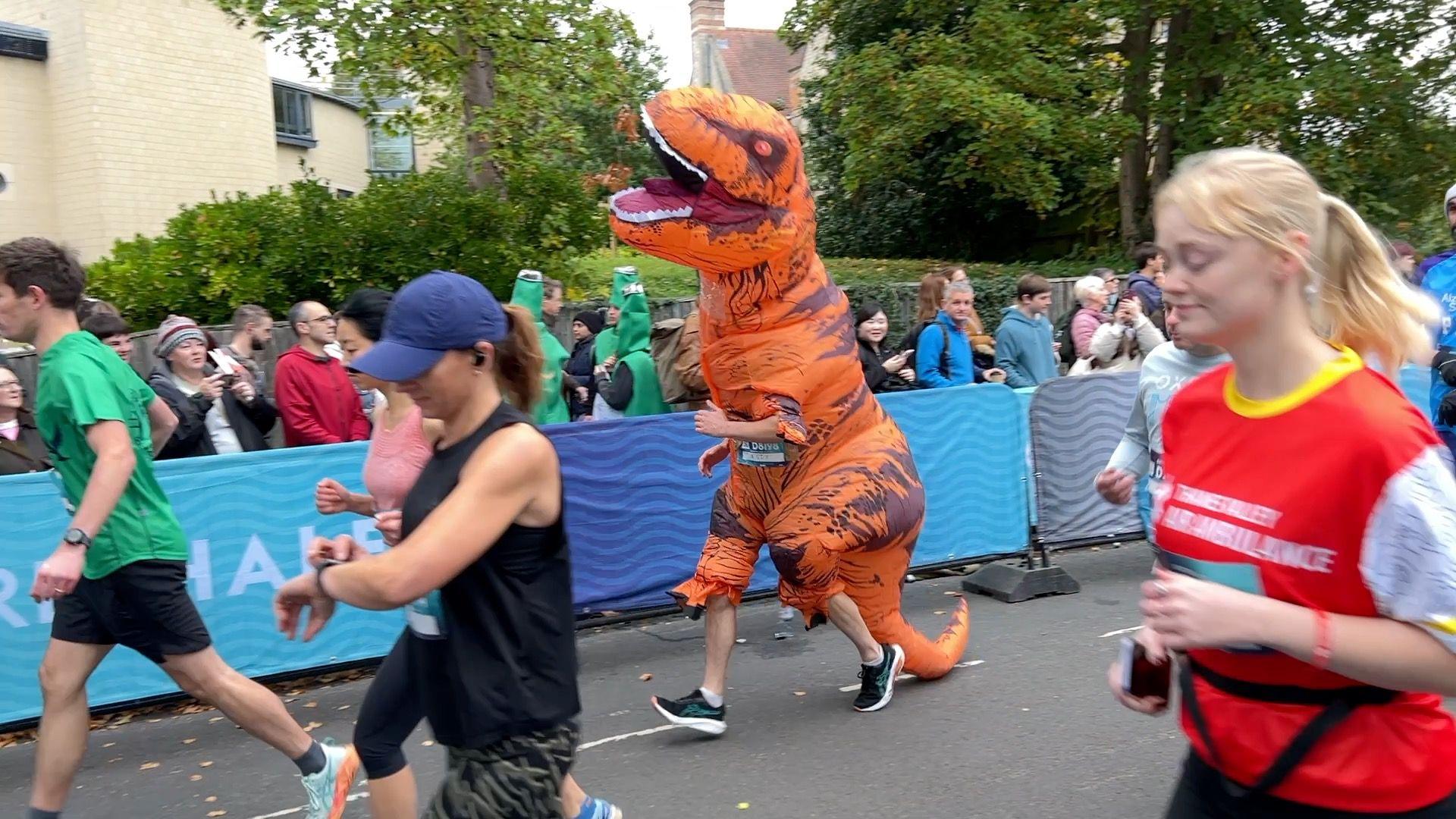 A man in a dinosaur costume runs the Oxford Half.
