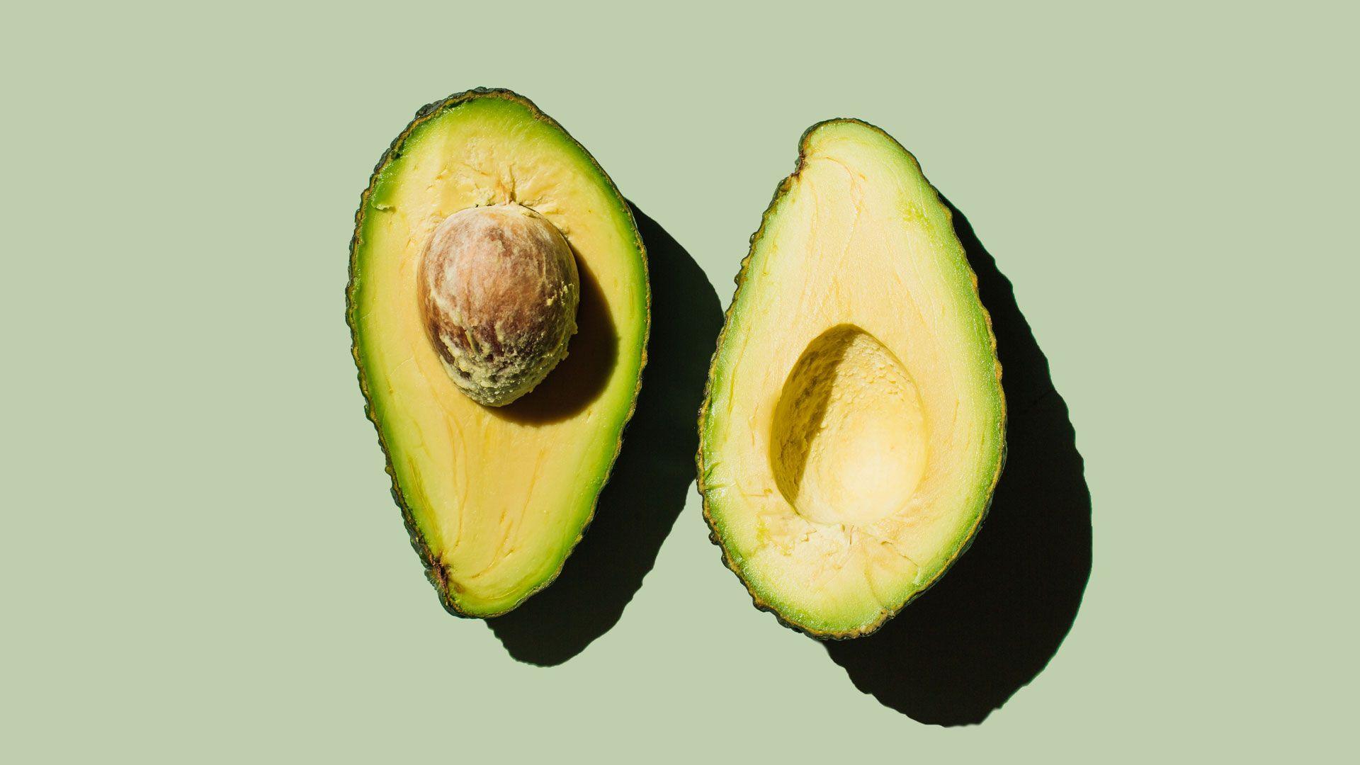 An avocado sliced in half with the stone still in it 