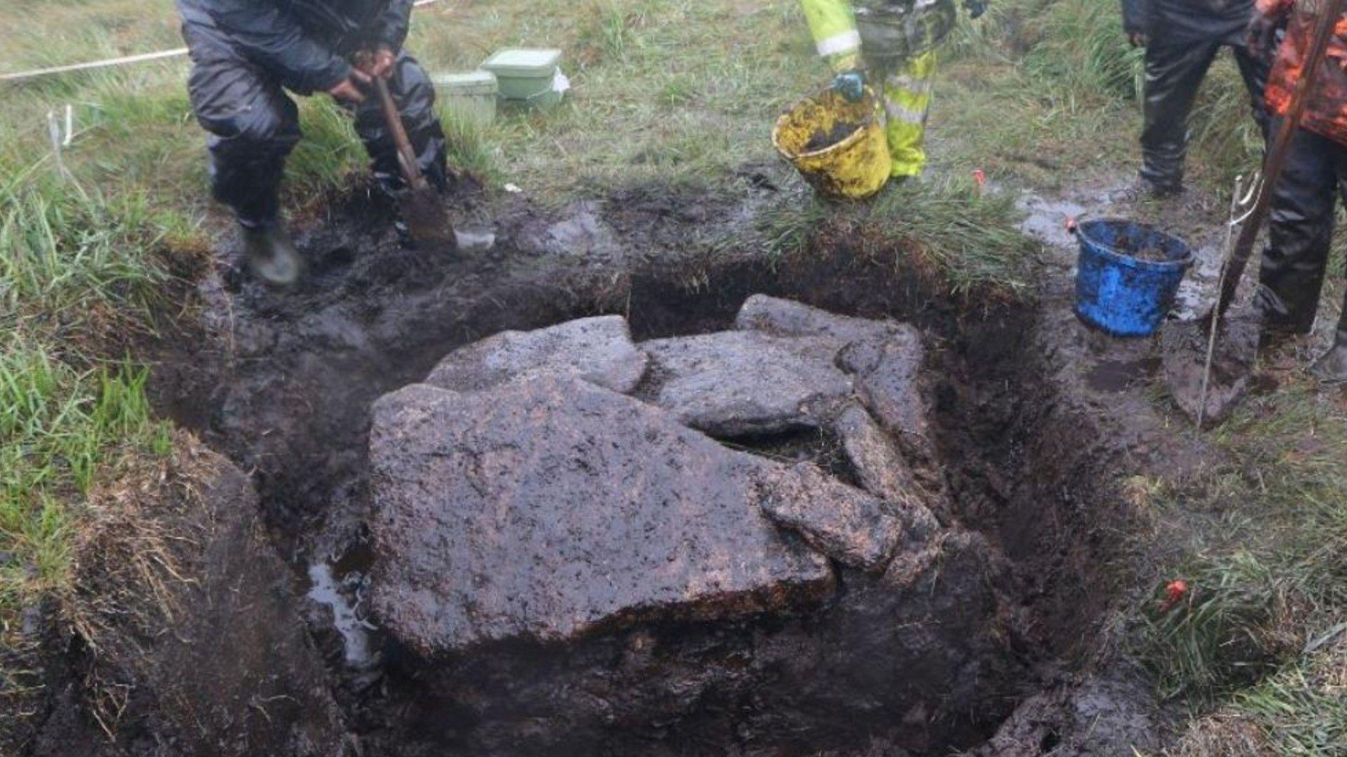 Archaeologists exploring cist at Cut Hill during excavations.