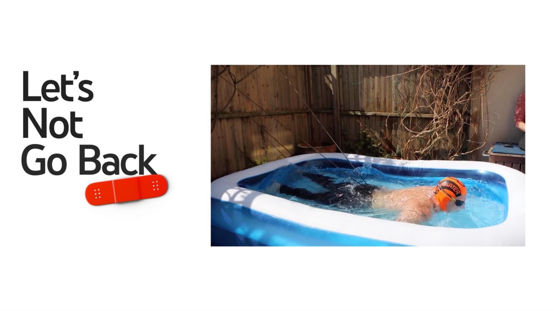 A man swimming in a paddling pool