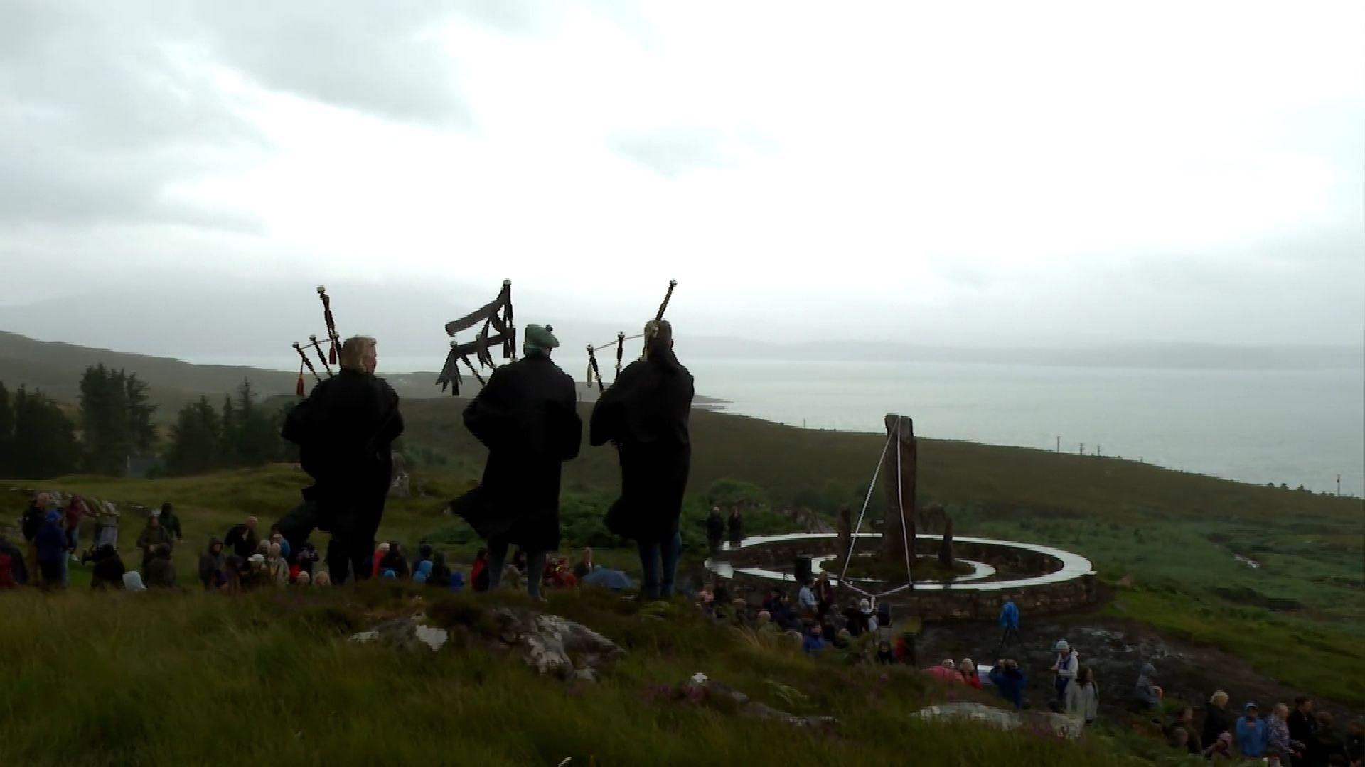 Pìobairean air beulaibh na carragh-cuimhne do strì an fhearainn sa Chòigich