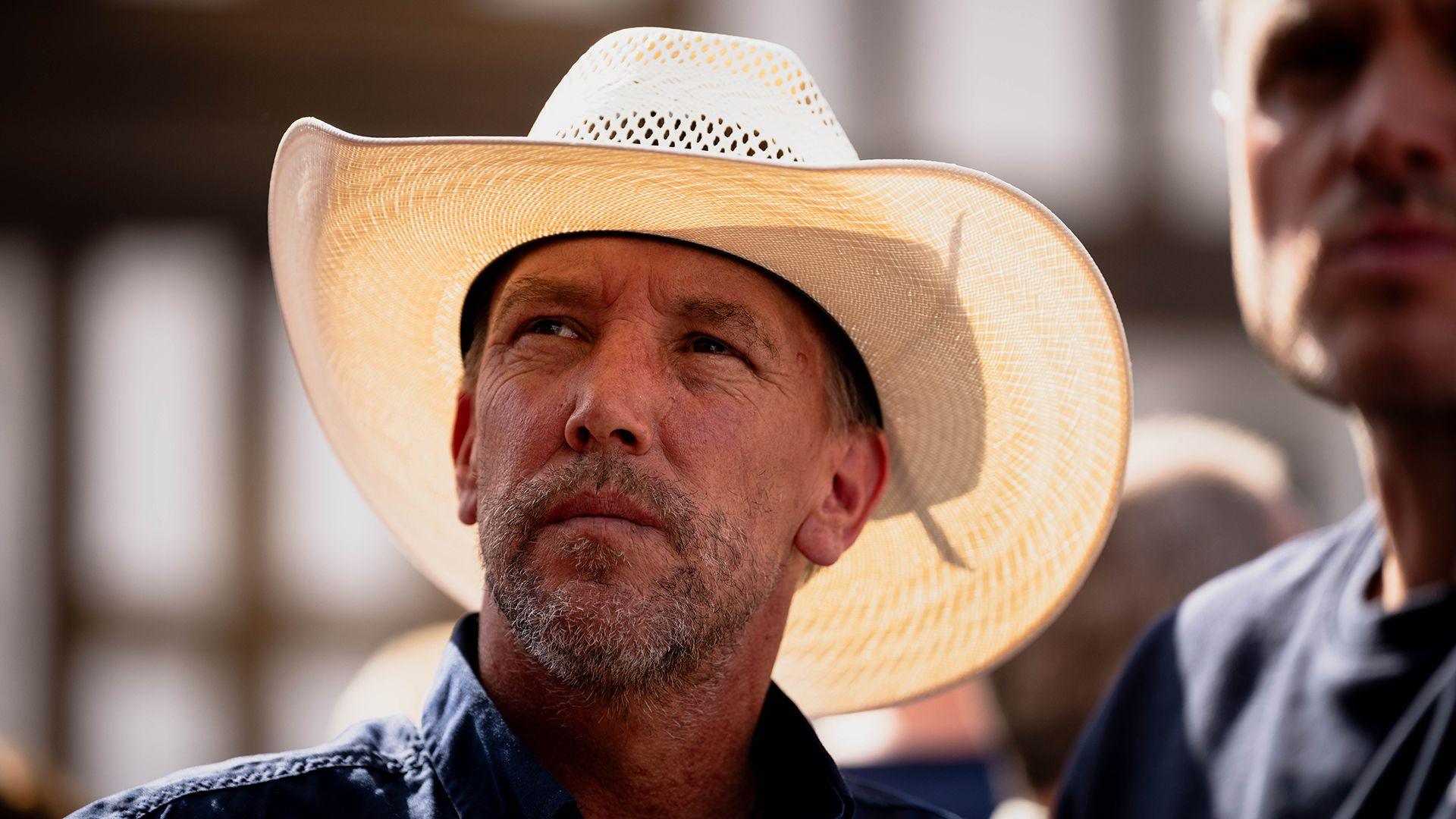 Dyn gyda het cowboi