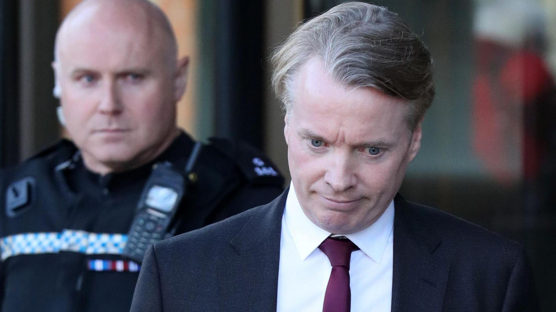 Craig Whyte, a middle aged man with sandy hair, outside court. He is looking down, while wearing a black blazer, a white shirt and a purple tie.