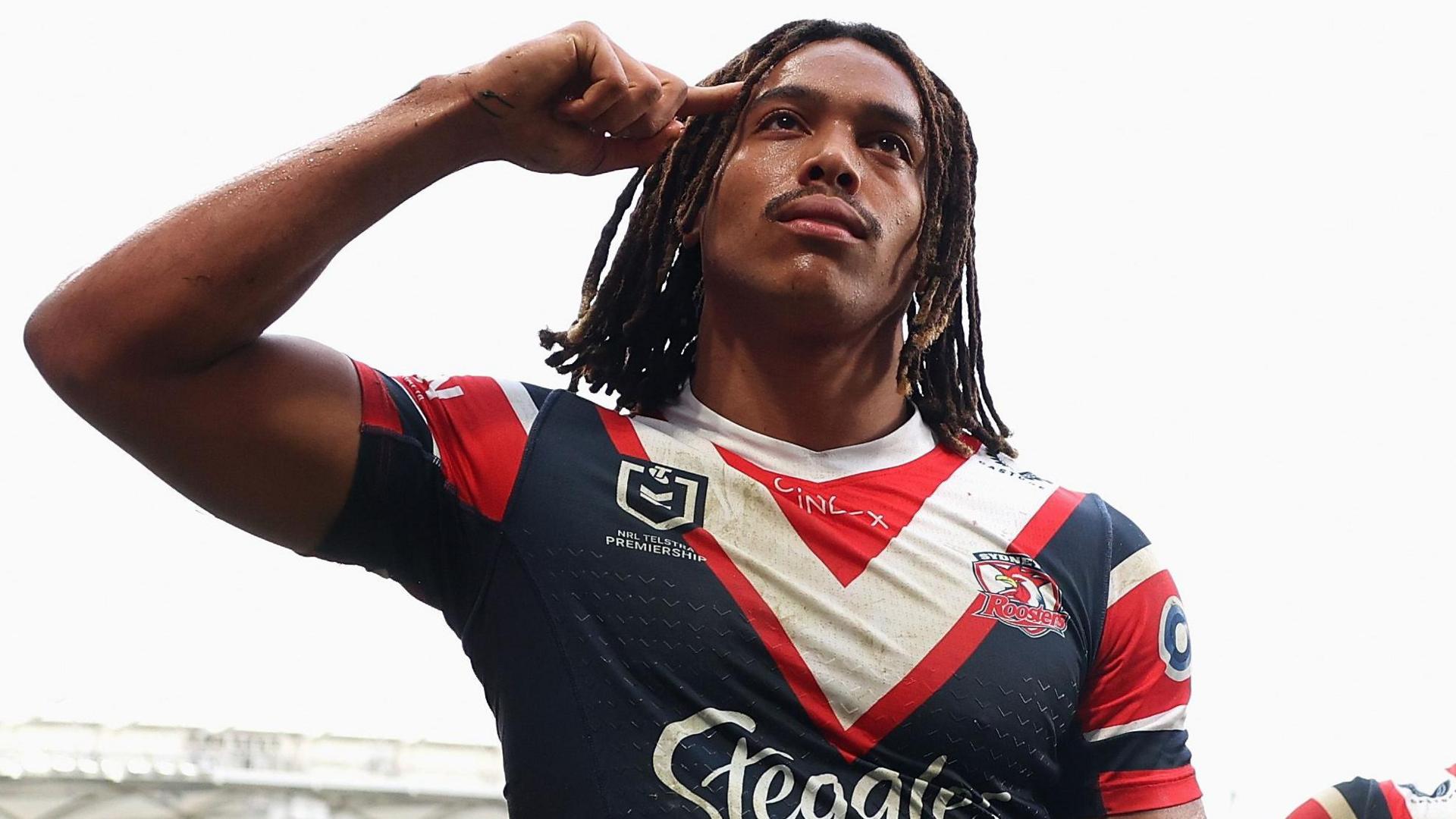 Dom Young salutes the crowd by pointing a finger to his temple after scoring for Sydney Roosters, a trademark celebration by the England winger