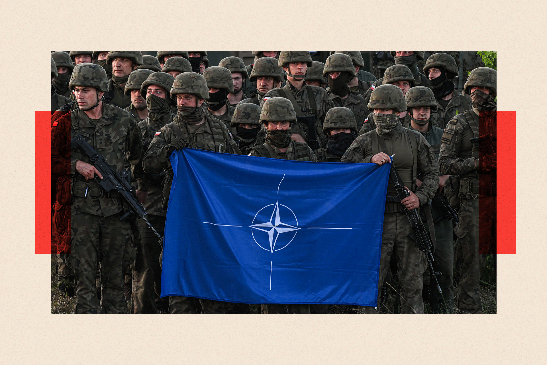 Polish soldiers hold up a NATO flag 