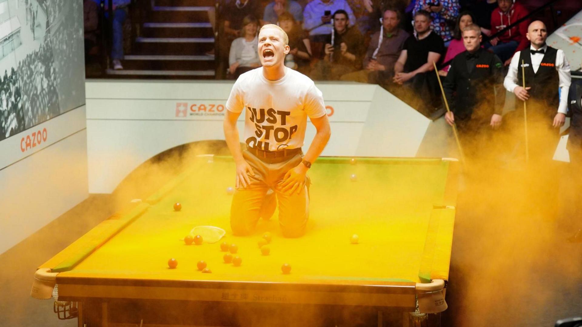 Man on a snooker table at the Crucible Theatre