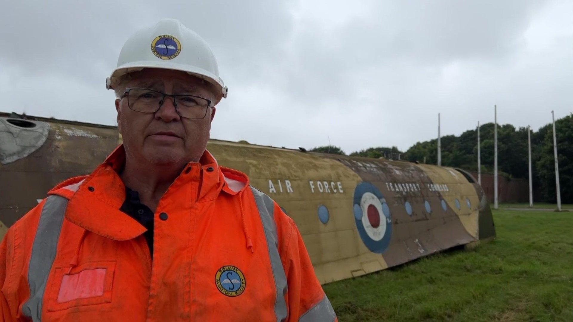 Dougie Kerr, from Solway Aviation Museum, standing in front of a section of the Blackburn Beverley. The RAF logo can be seen on the side of the vehicle.