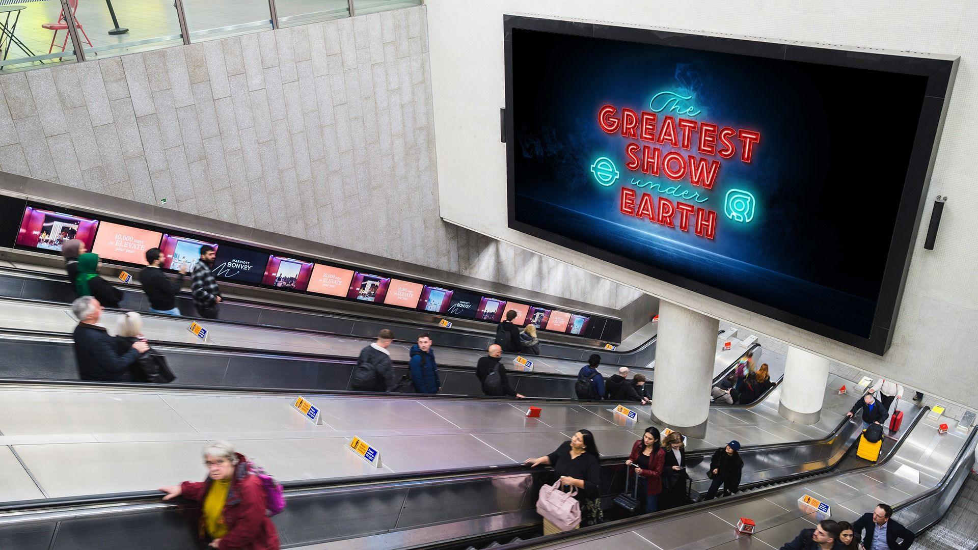 Escalators at a Tube station lined with digital advertising screens