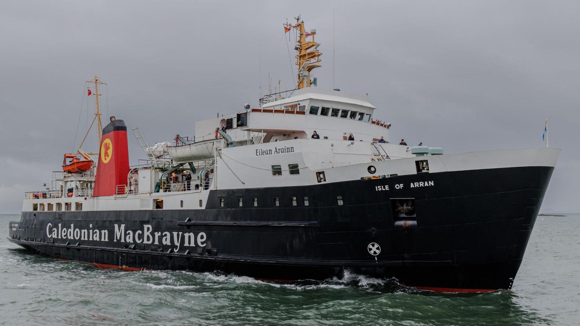 The Isle of Arran is a large ship. It is painted black and white with a red, black-topped funnel with the red and yellow lion rampant logo of CalMac.