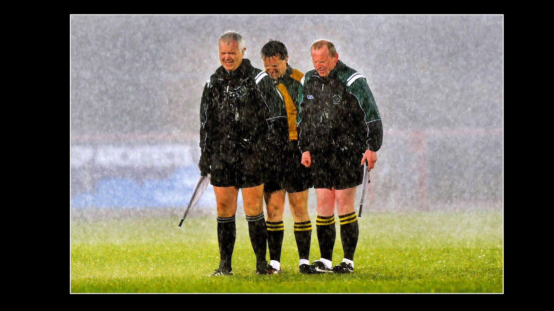 Former referee and BBC Sport pundit Maurice Deegan in the rain with his assistants before a league match