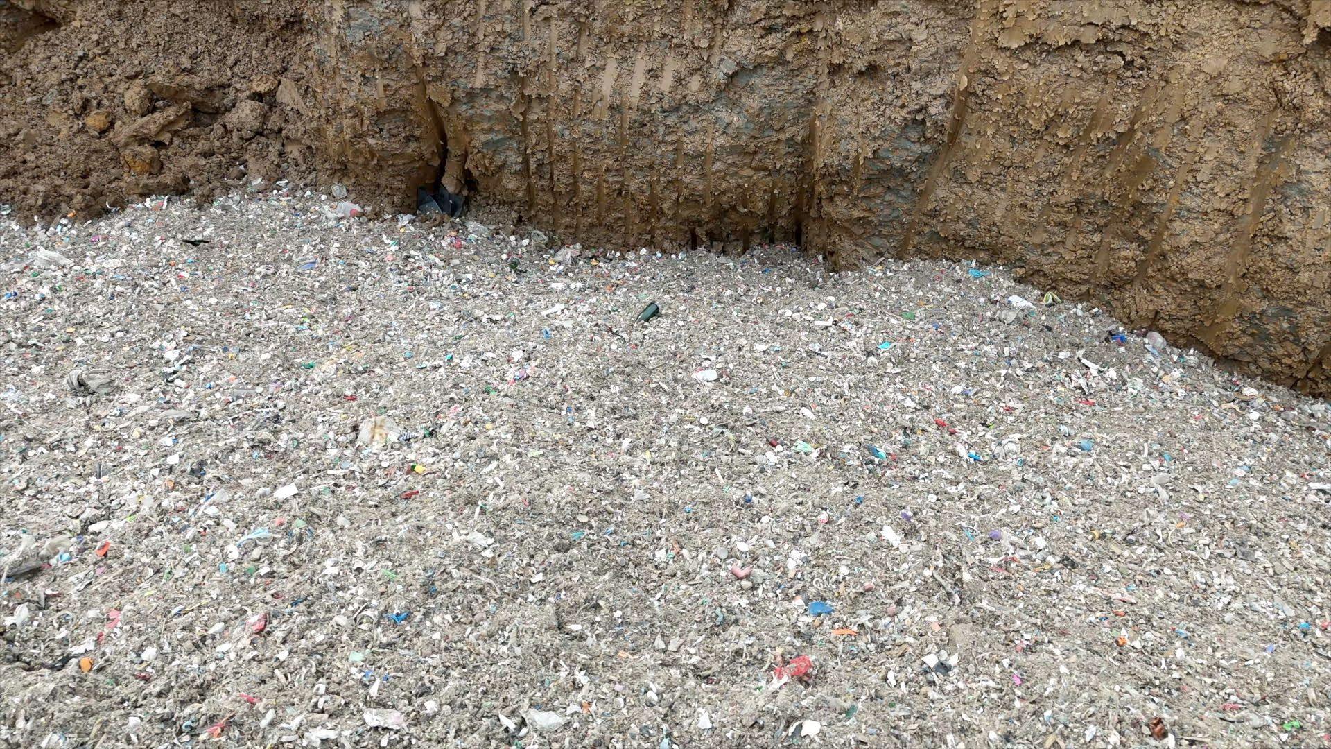 An aerial shot of a mound of waste with what appears to be pieces of plastic among it