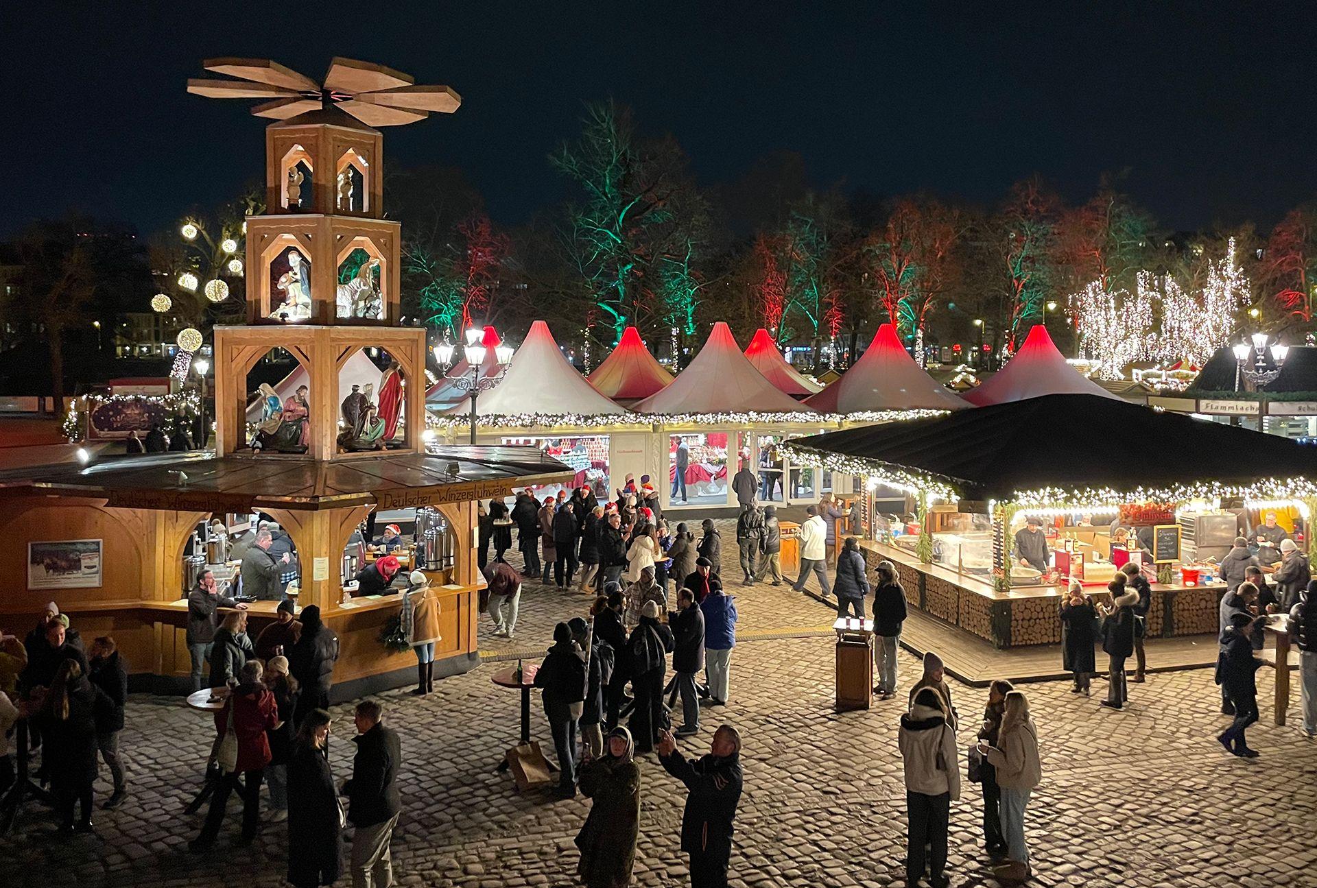 High angle photos of Berlin Christmas market. People stand at wooden stalls