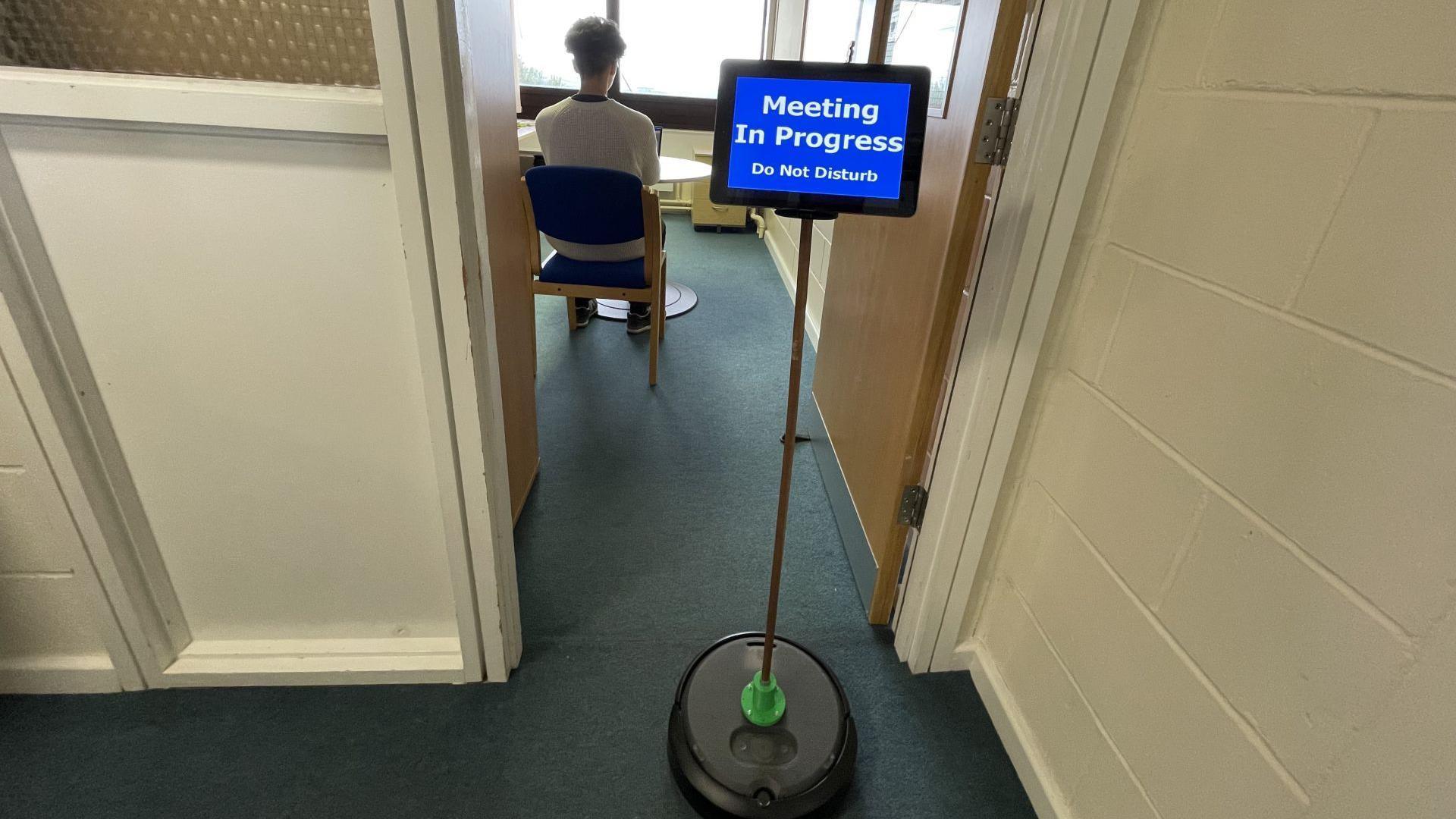 A screen showing 'do not disturb' on a robot that was programmed to go to a specific location, to help minimise possible disturbances