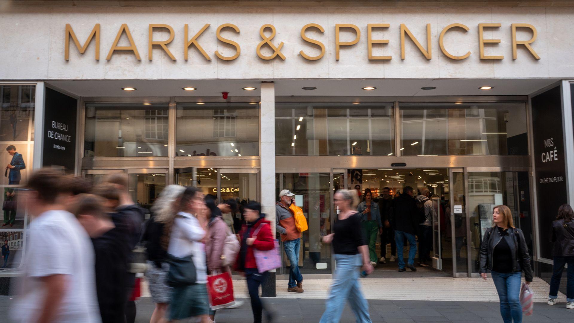 A M&S storefront with the words 'Marks & Spencer' above the doors to the store and shoppers walking outside the store, pictured in Bath in September 2024