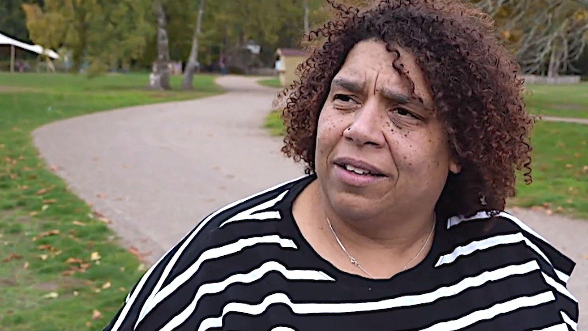Woman at Sandringham estate with path and woods behind her, looking at the camera.