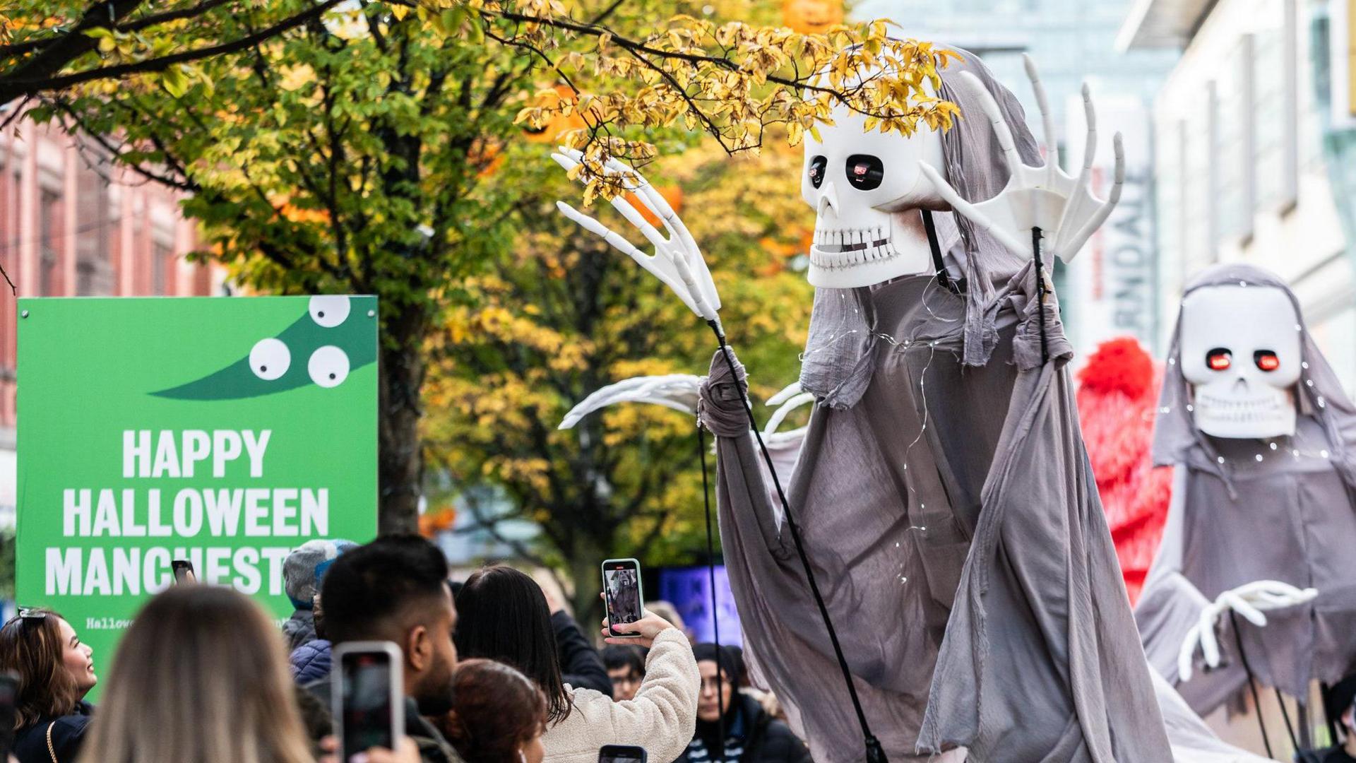 A grim reaper figure with a skull face at large in central Manchester