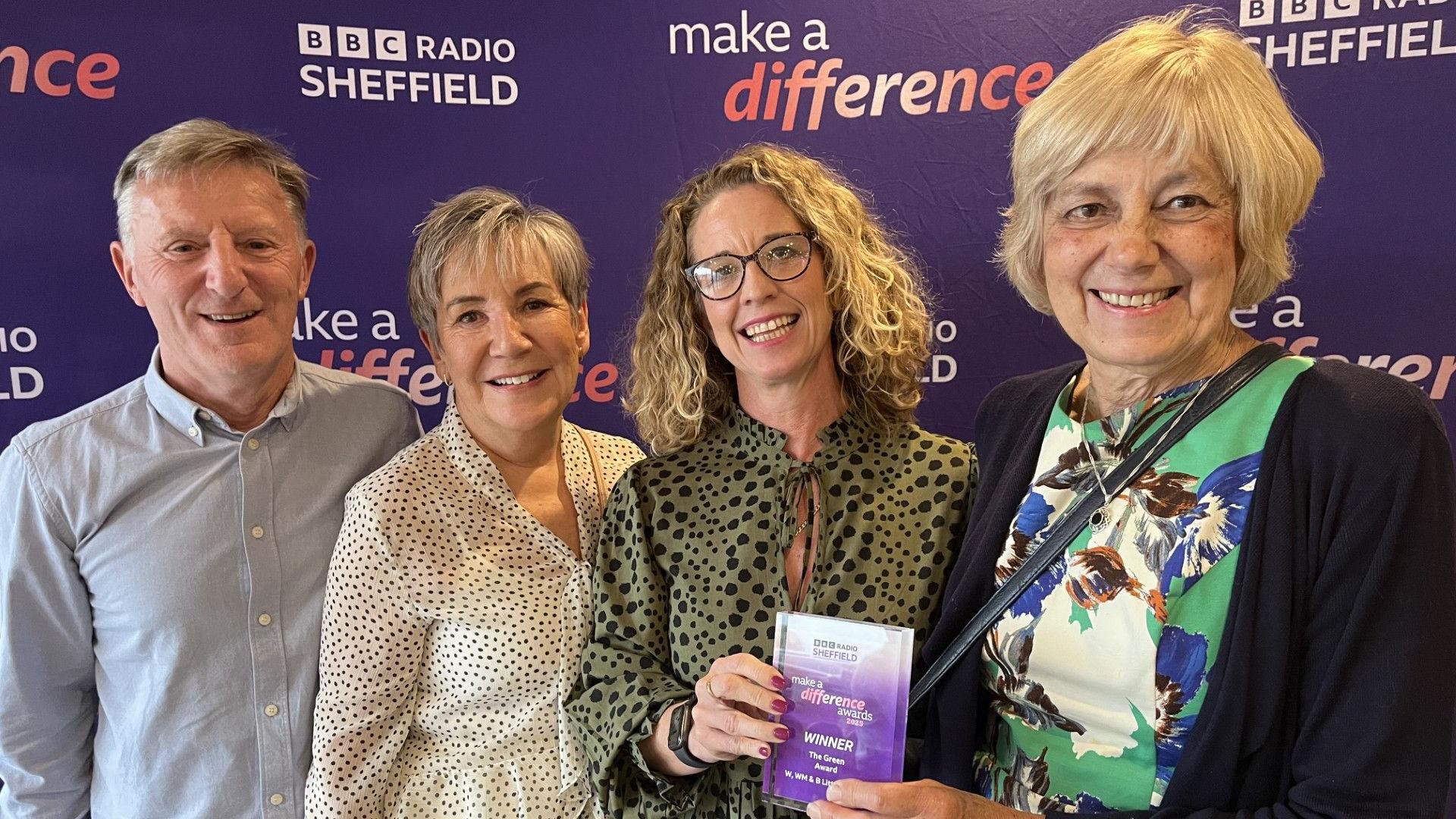 Three women and a man receive an award for litter picking