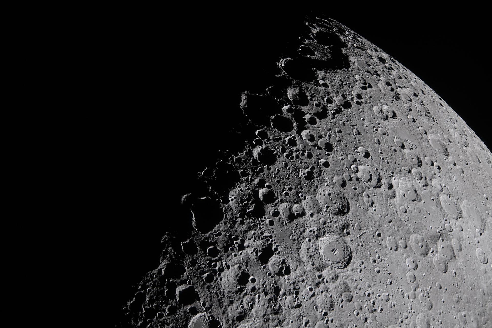 an up close image of the moon where the top left is in darkness and the bottom right is in light, where you can see lots of craters, ridges and basins