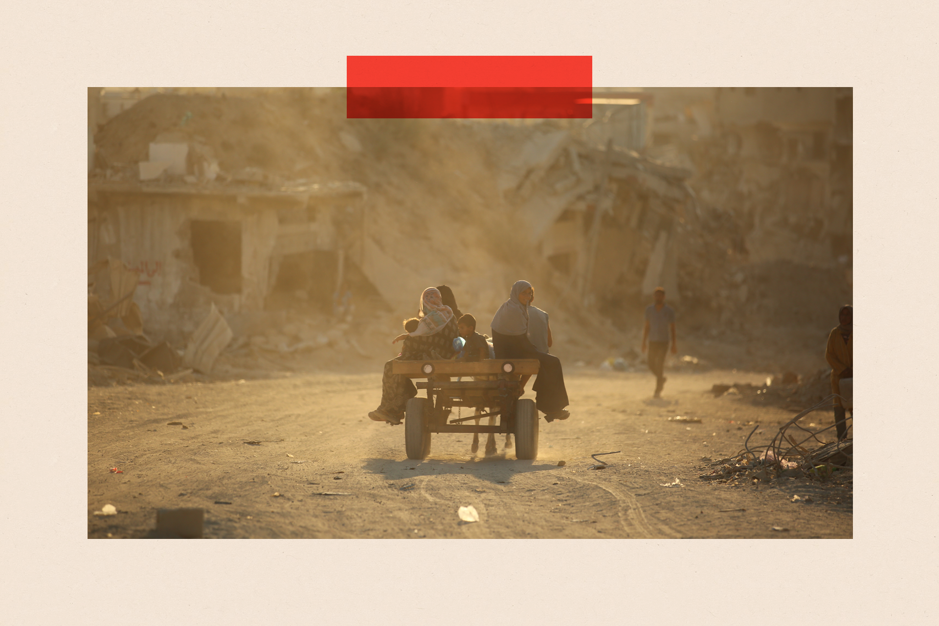 A group of people sit on a wooden cart pulled by an animal, surrounded by rubble and ruined buildings.