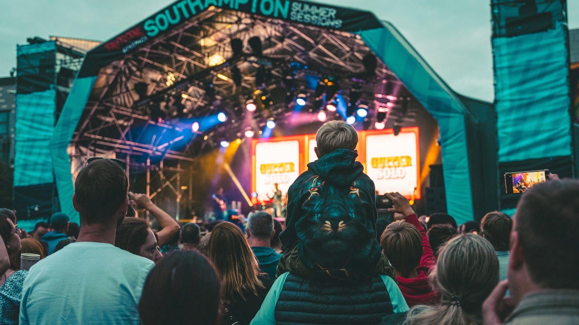 Crowds watch Kaiser Chiefs in Southampton, a boy sits on someone's shoulders