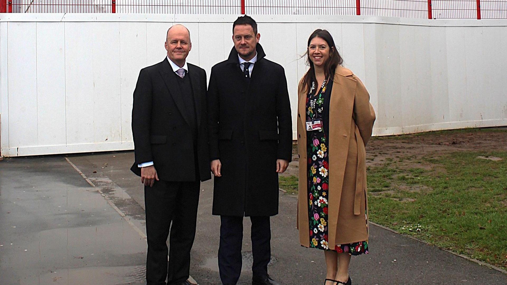 Education Minster Stephen Morgan (centre) standing next to the Bridgwater MP Ashley Fox (left) and the interim head teacher Leanne Mills (right) in front of the condemned building at Haygrove Sch
