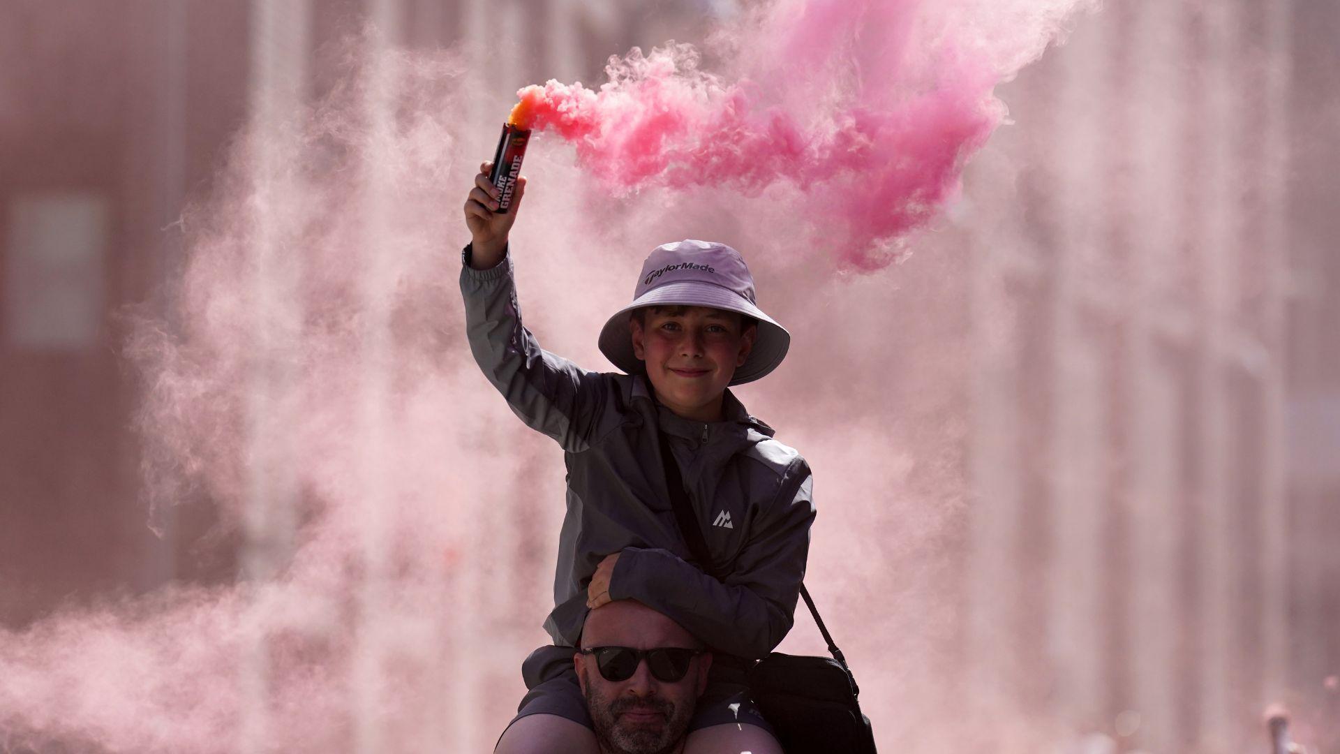 A young fan holding a smoke flare makes their towards Wembley Stadium