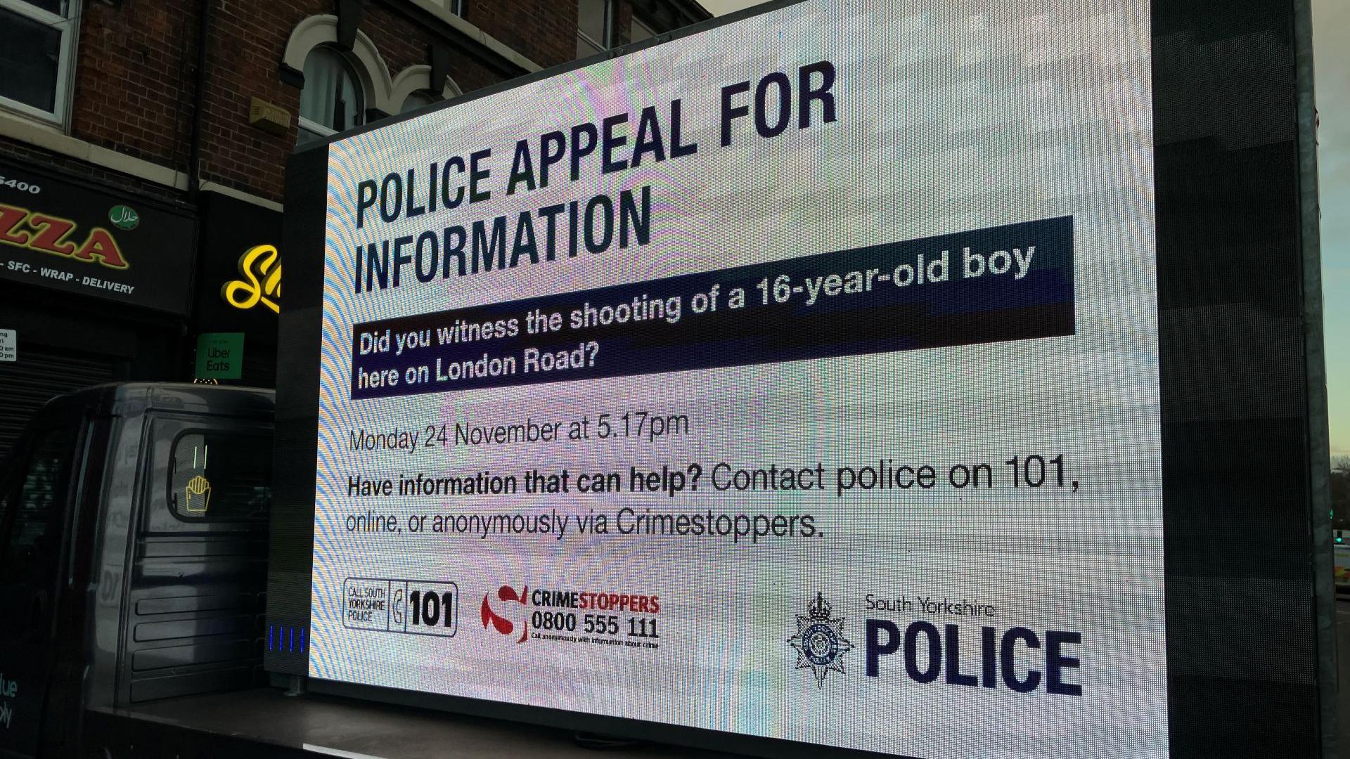 A mobile advertising board with the message, Police appeal for information. Did you witness the shooting of a 16-year-old boy here on London Road? Monday 24 November at 5.17pm.