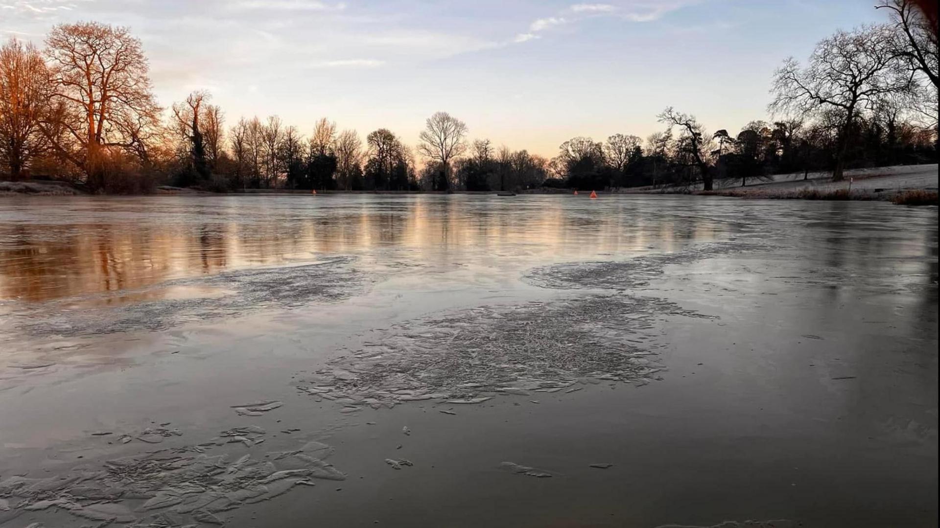 A lake with large ice patches all over it. 