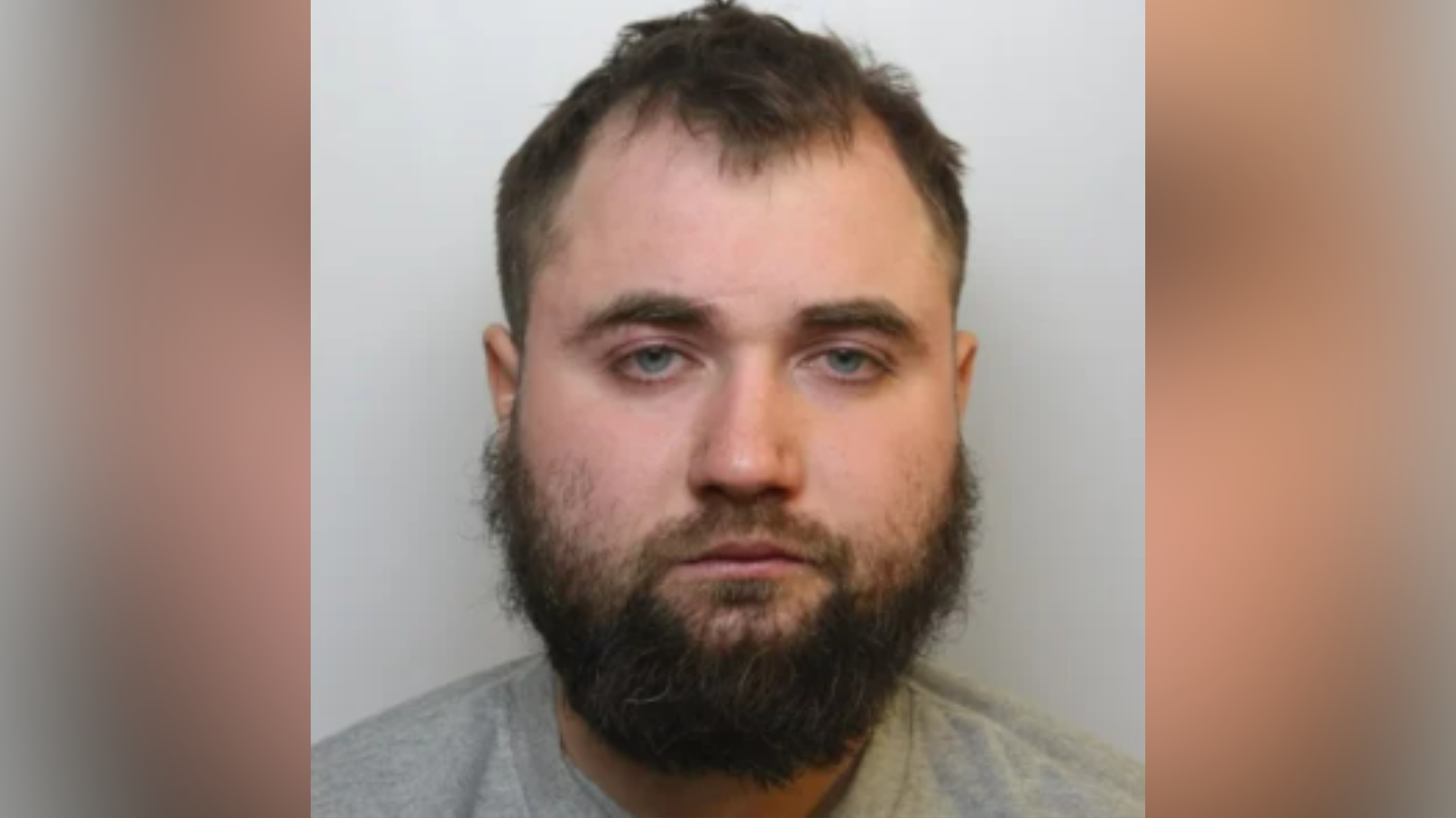 Victor Rotundu is looking at the camera in a police custody picture. He has a bushy, unkept beard.