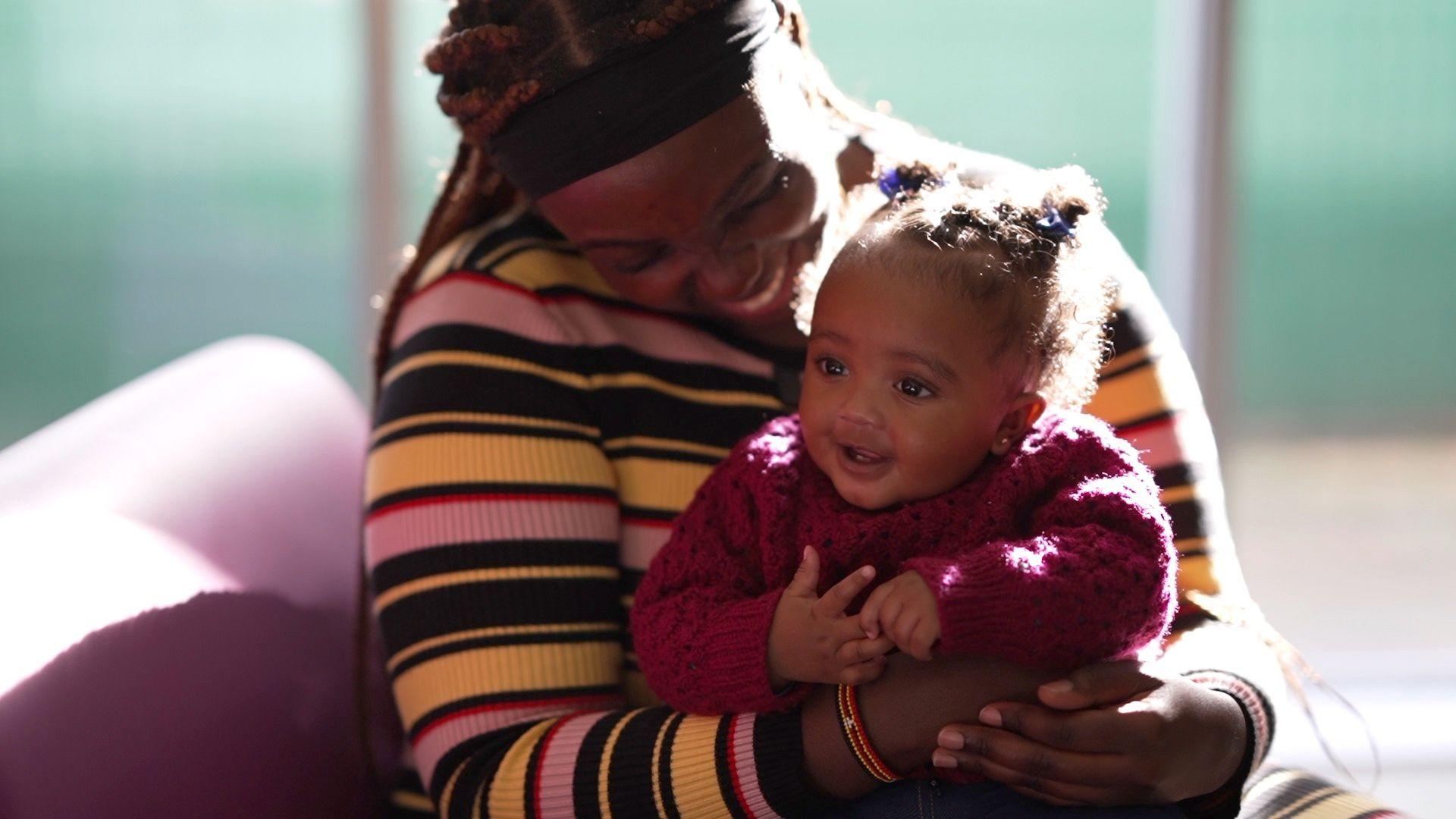 A happy baby smiling with her mother