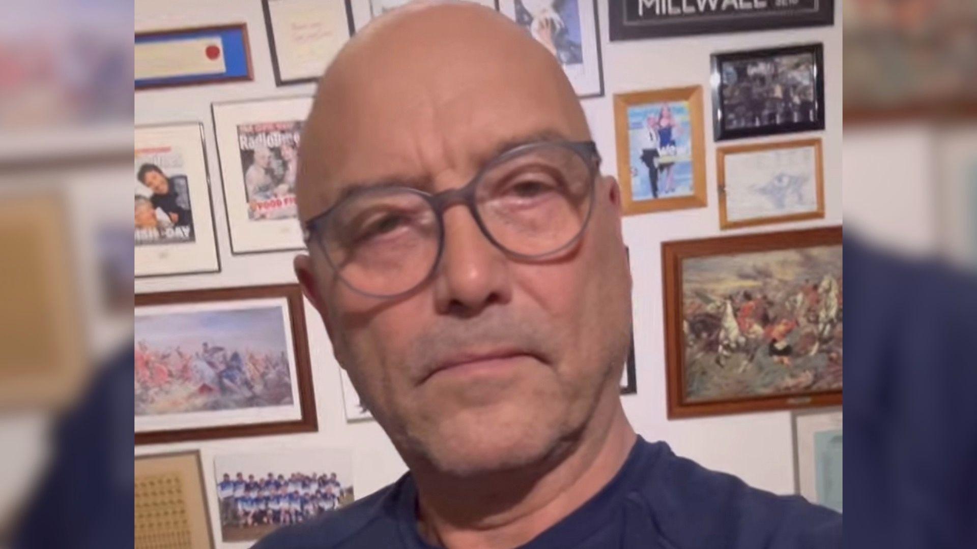 Man with glasses in navy T shirt looks at camera