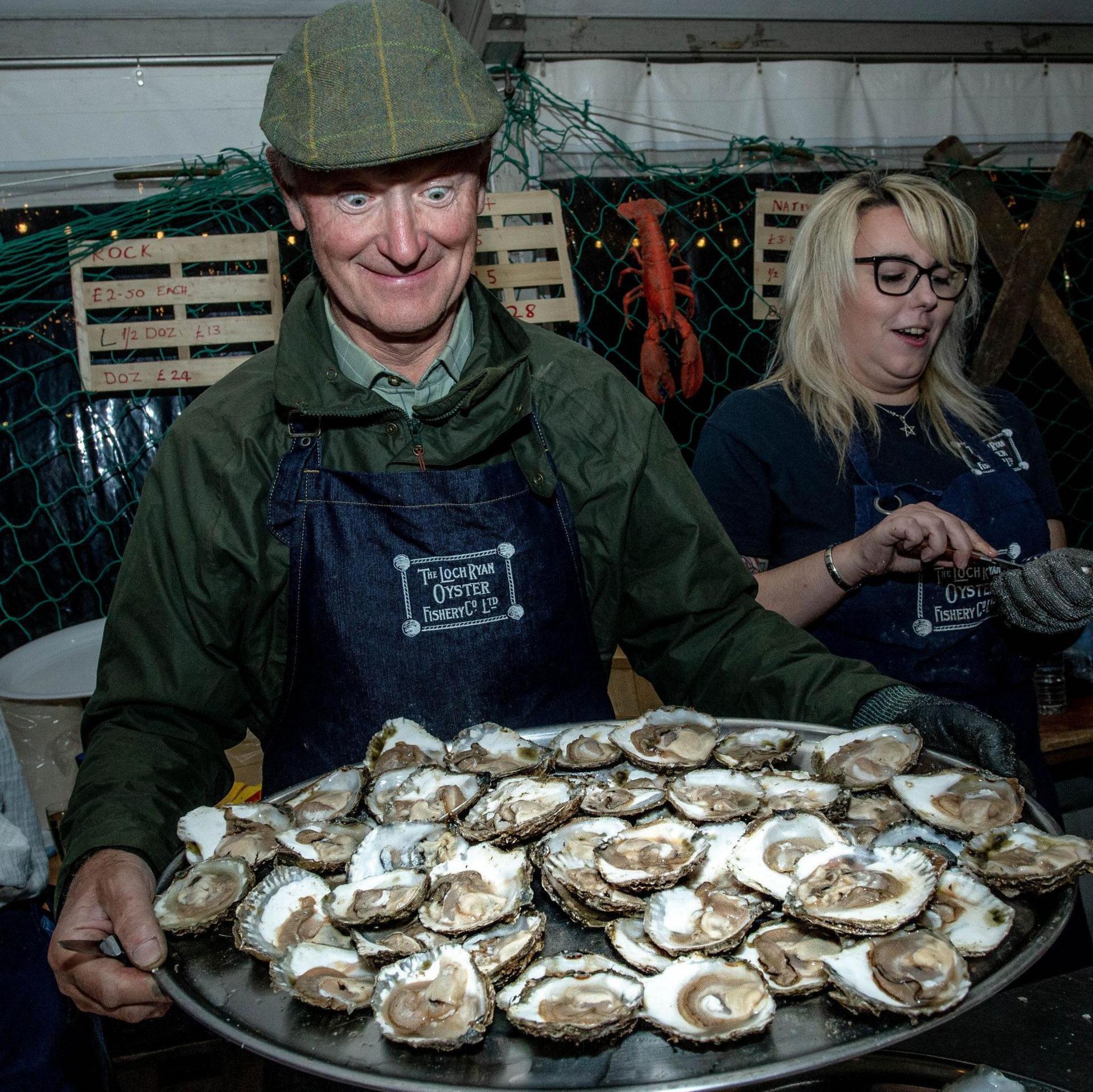 A man eyeing up a huge plate of oysters