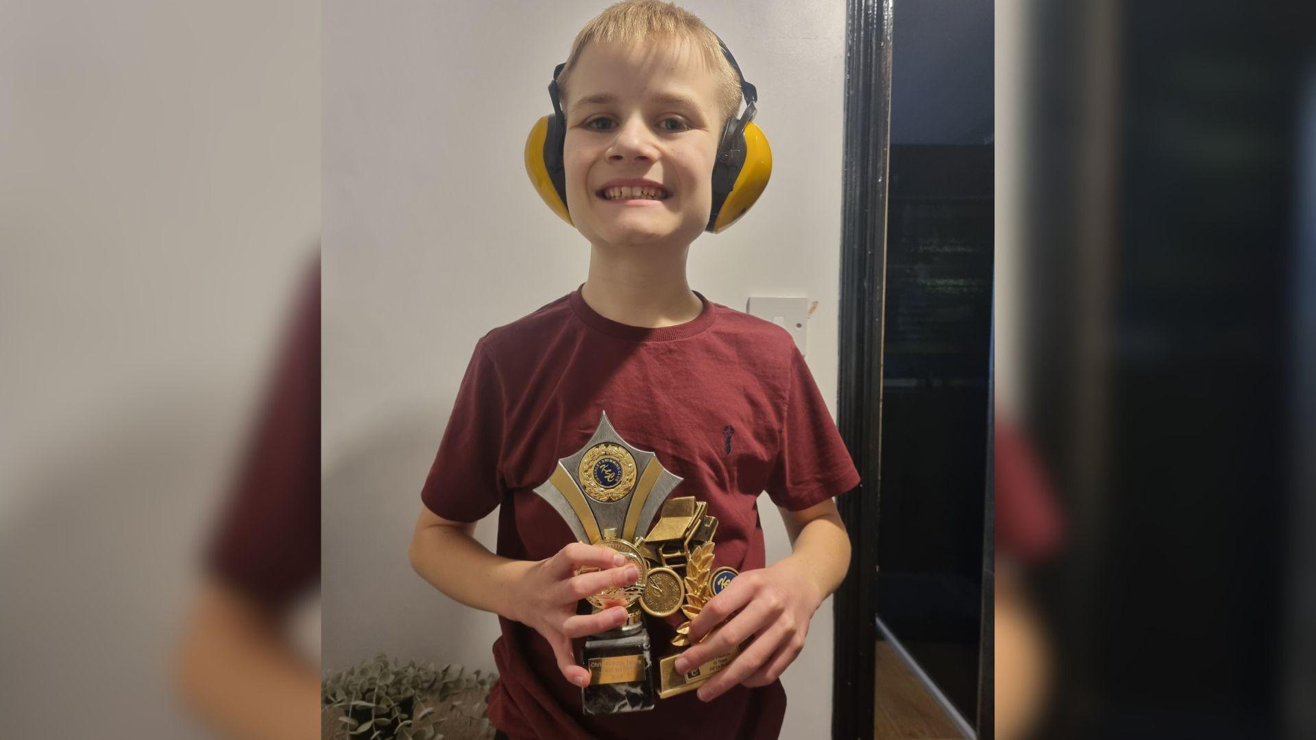 Abbie Thompson's son holding the trophy he got from the Kimberley Swimming Club for dedication.