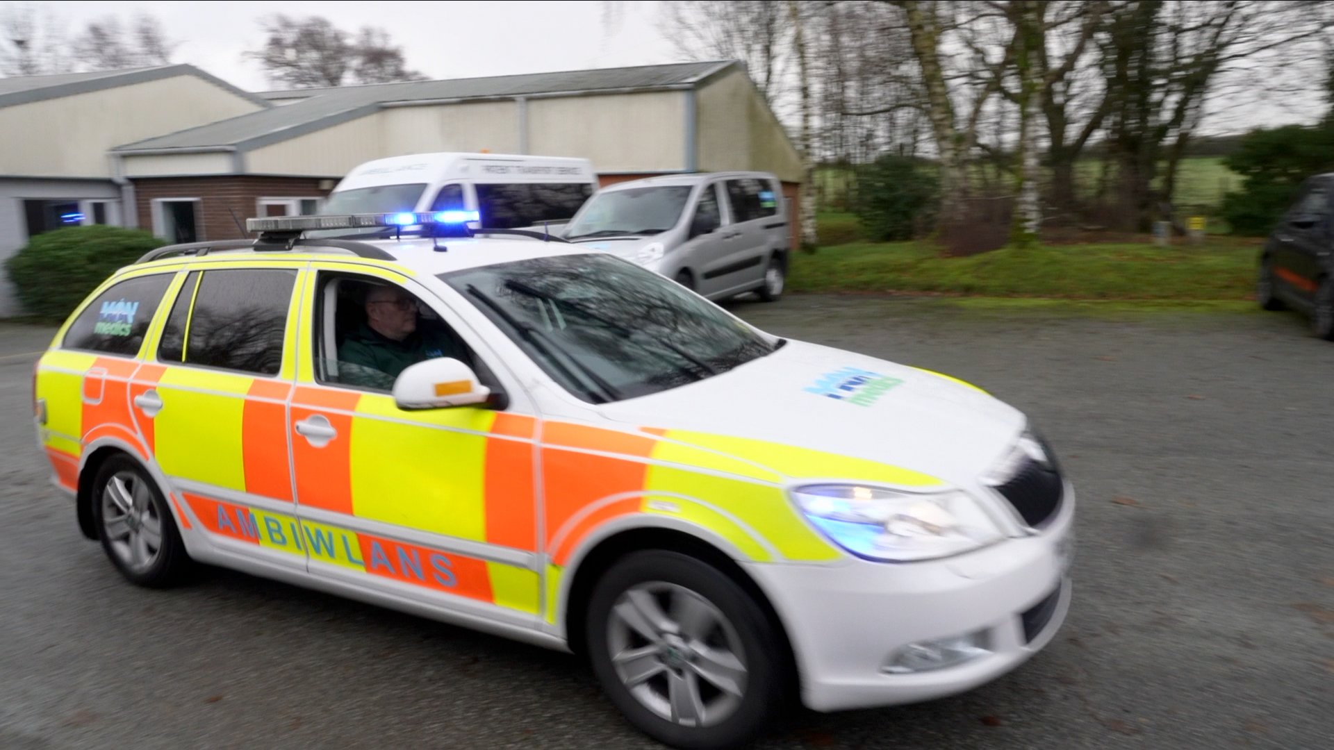 Môn Medics ambulance with blue lights drives past