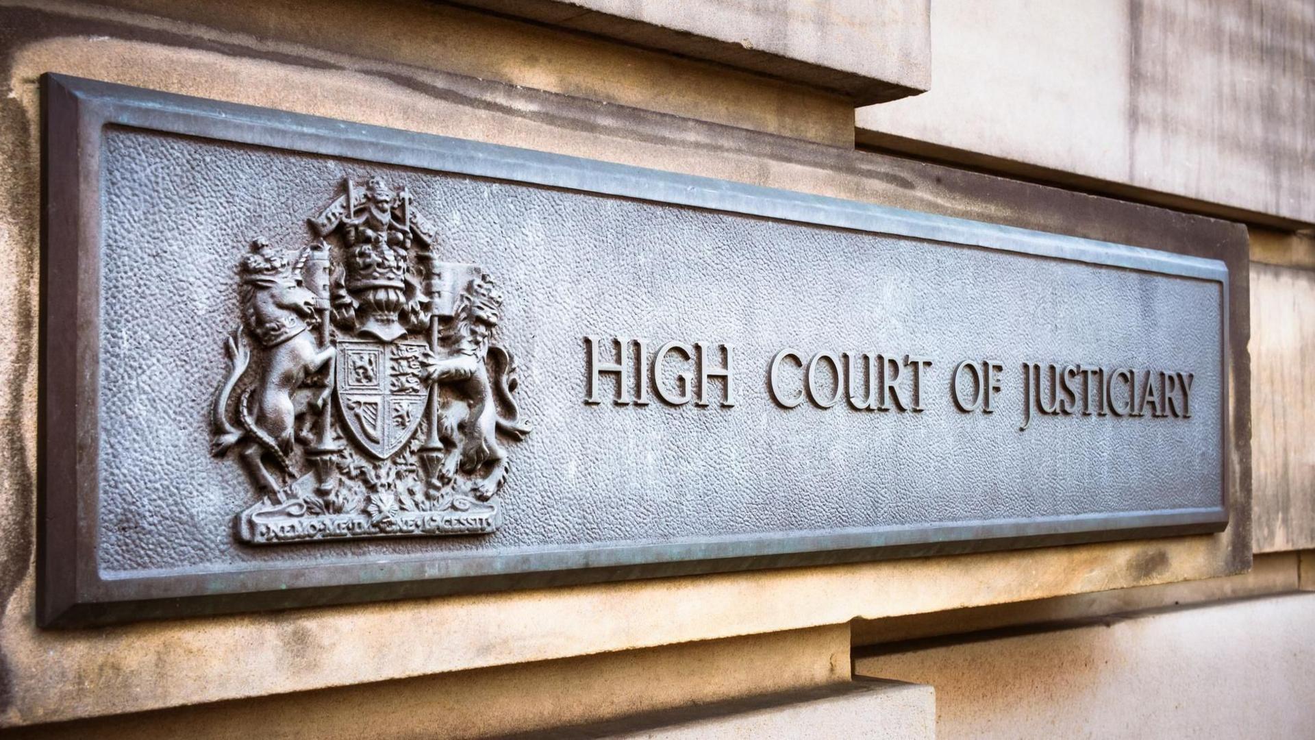 Close up of the iron High Court of Justiciary building sign in Edinburgh, featuring a coat of arms.