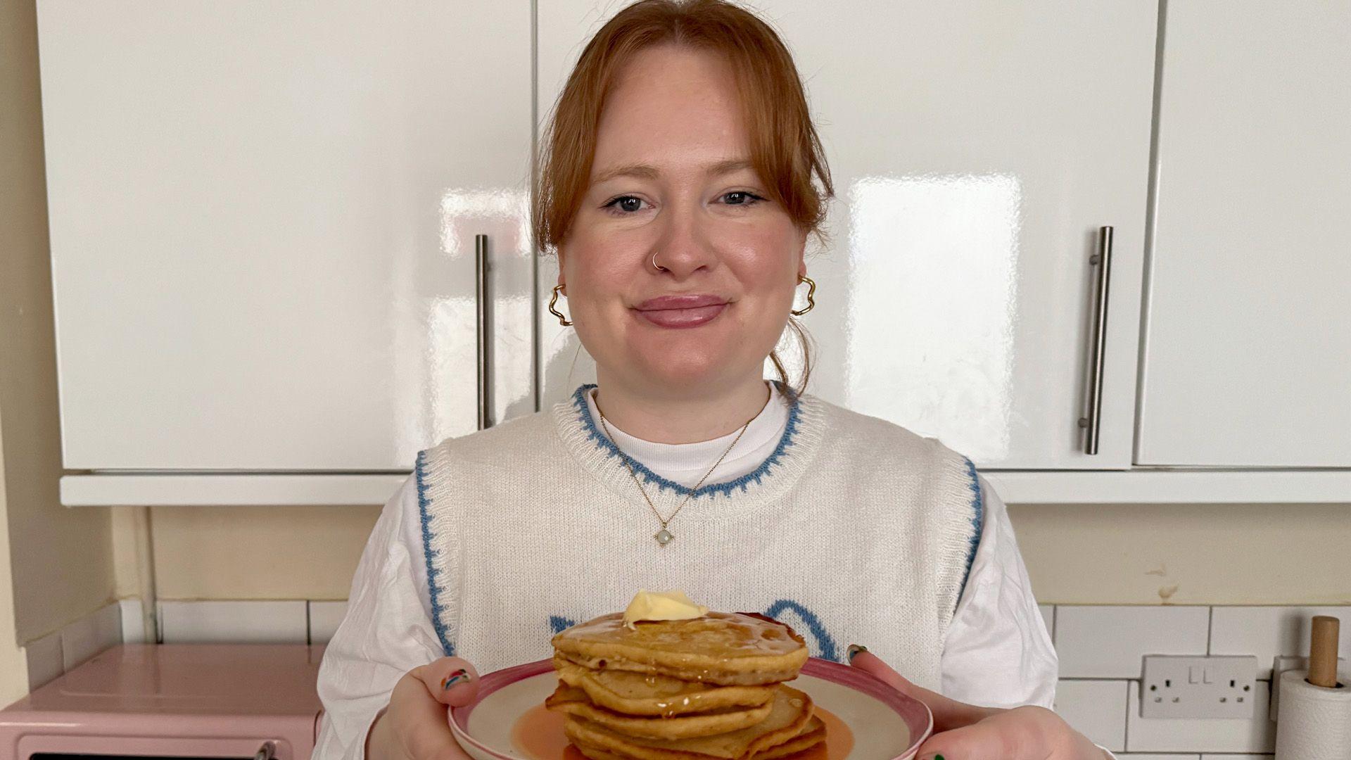 Izzie Cox holding her plate of American style pancakes 