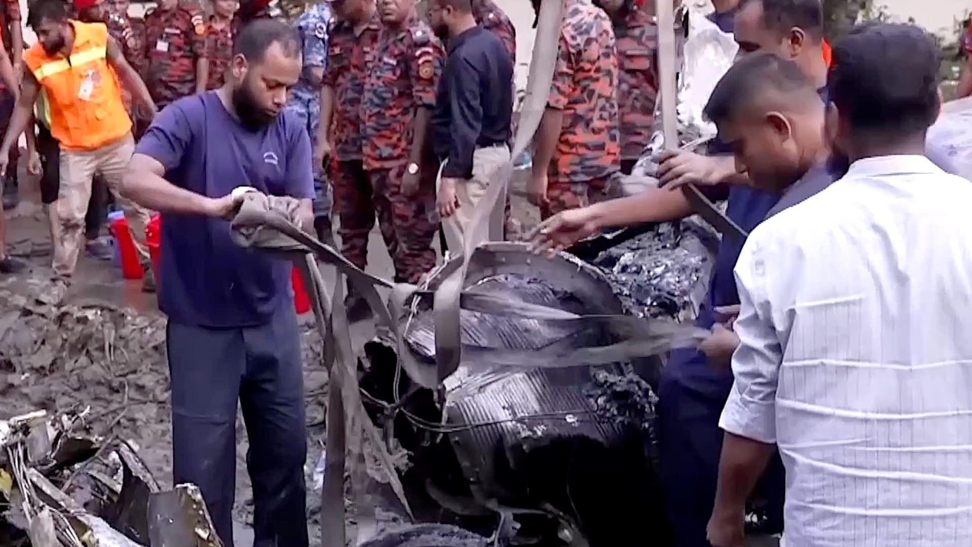 People clear debris at plane crash site