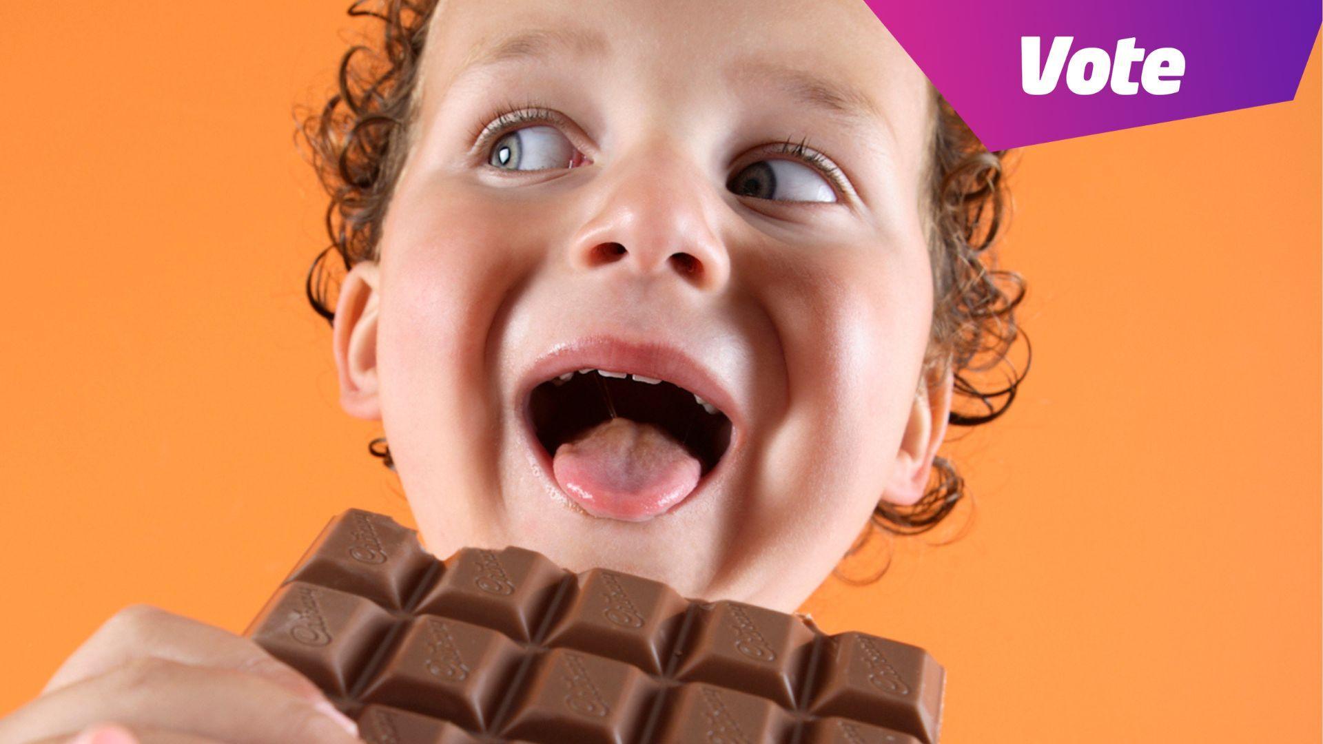 A boy about to bite a chocolate bar