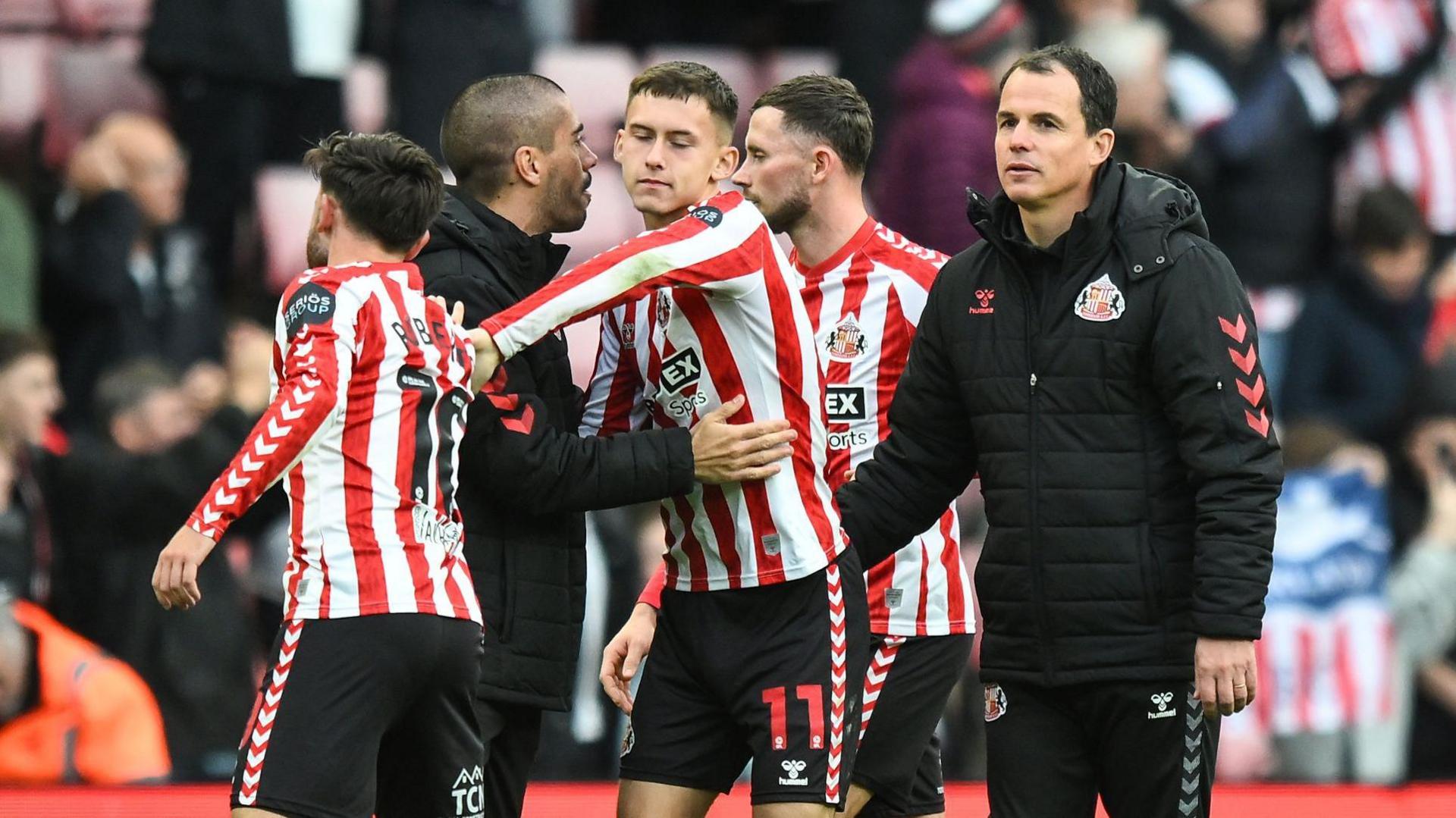 Sunderland manager Regis Le Bris congratulates his players during their victory against Oxford United