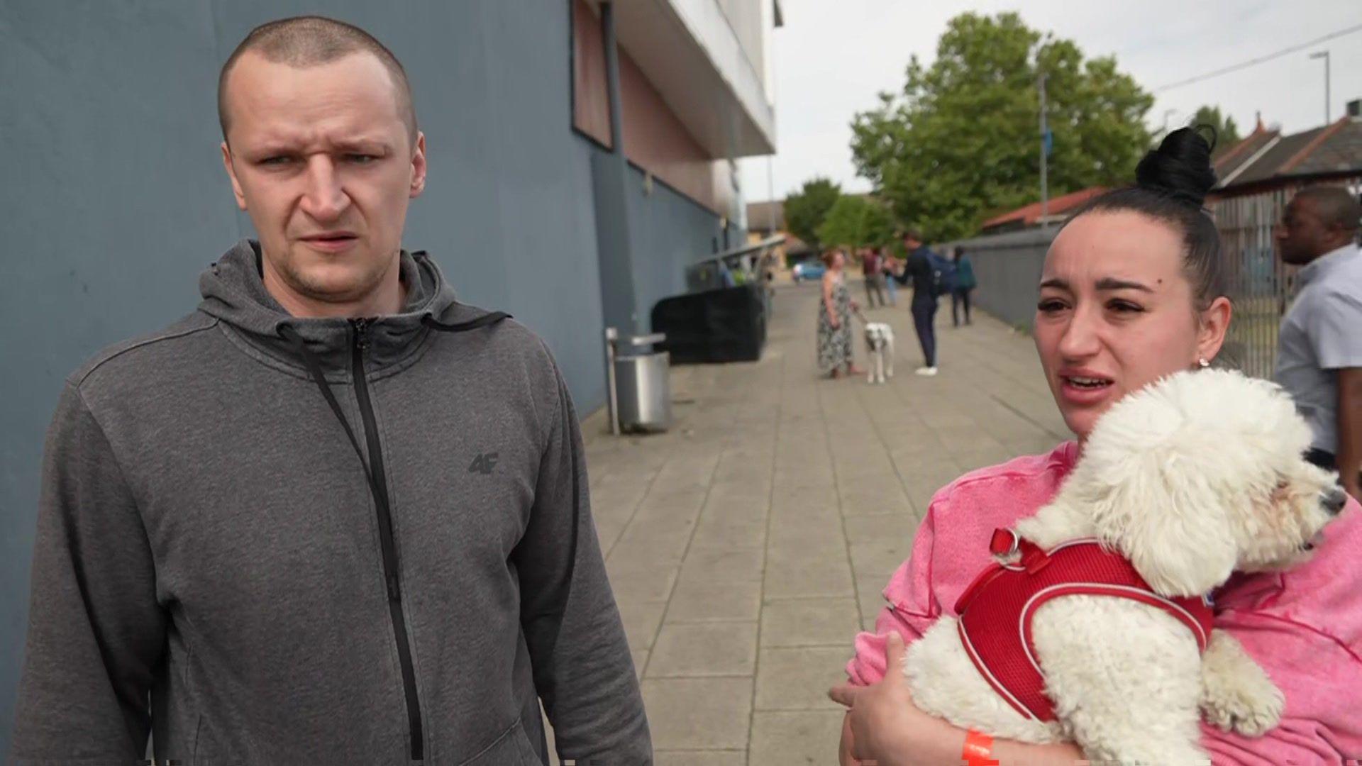 Lukasz and Agnizeszk stand outside a rest area at a leisure centre in Dagenham, east London after a fire at their tower block in Freshwater Road on Monday 26 August